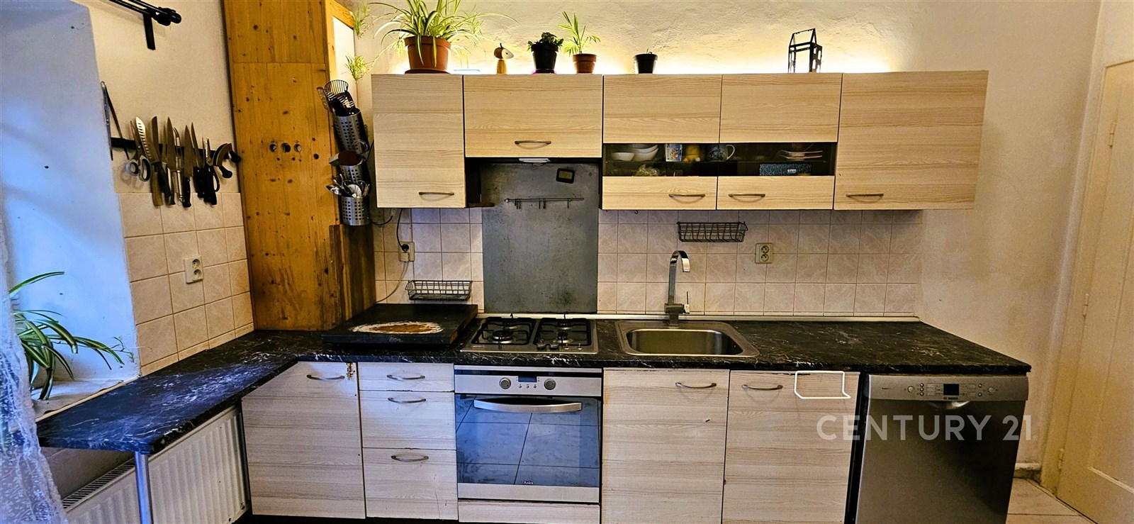 Moderní kuchyň s dřevěnými skříňkami, tmavou praco