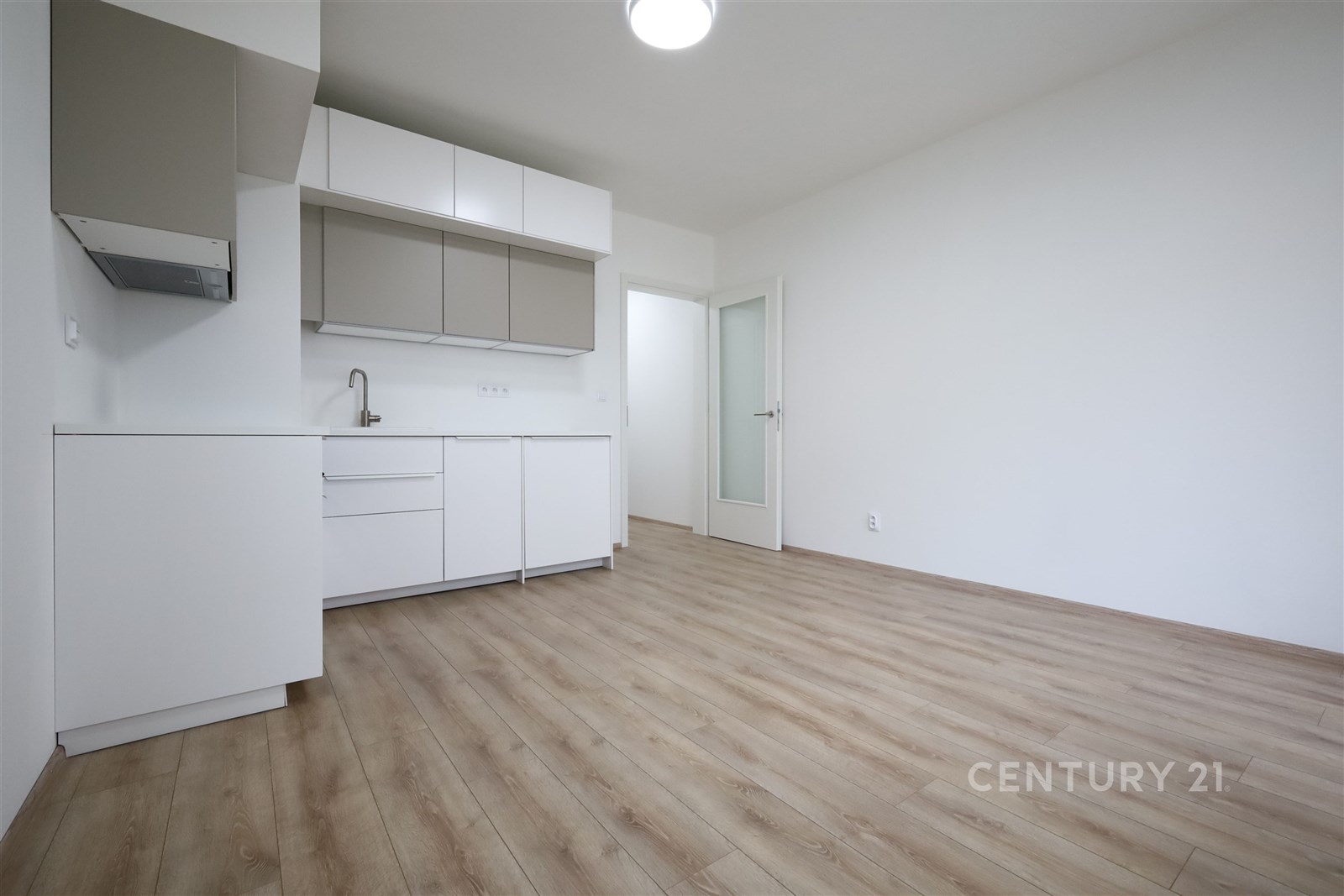 Moderní kuchyň s parketovou podlahou, bílými skříň