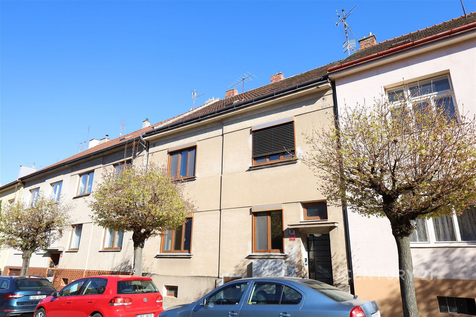 Fasáda řadového domu s moderními prvky, plastová okna, klidná lokalita, parkování před domem