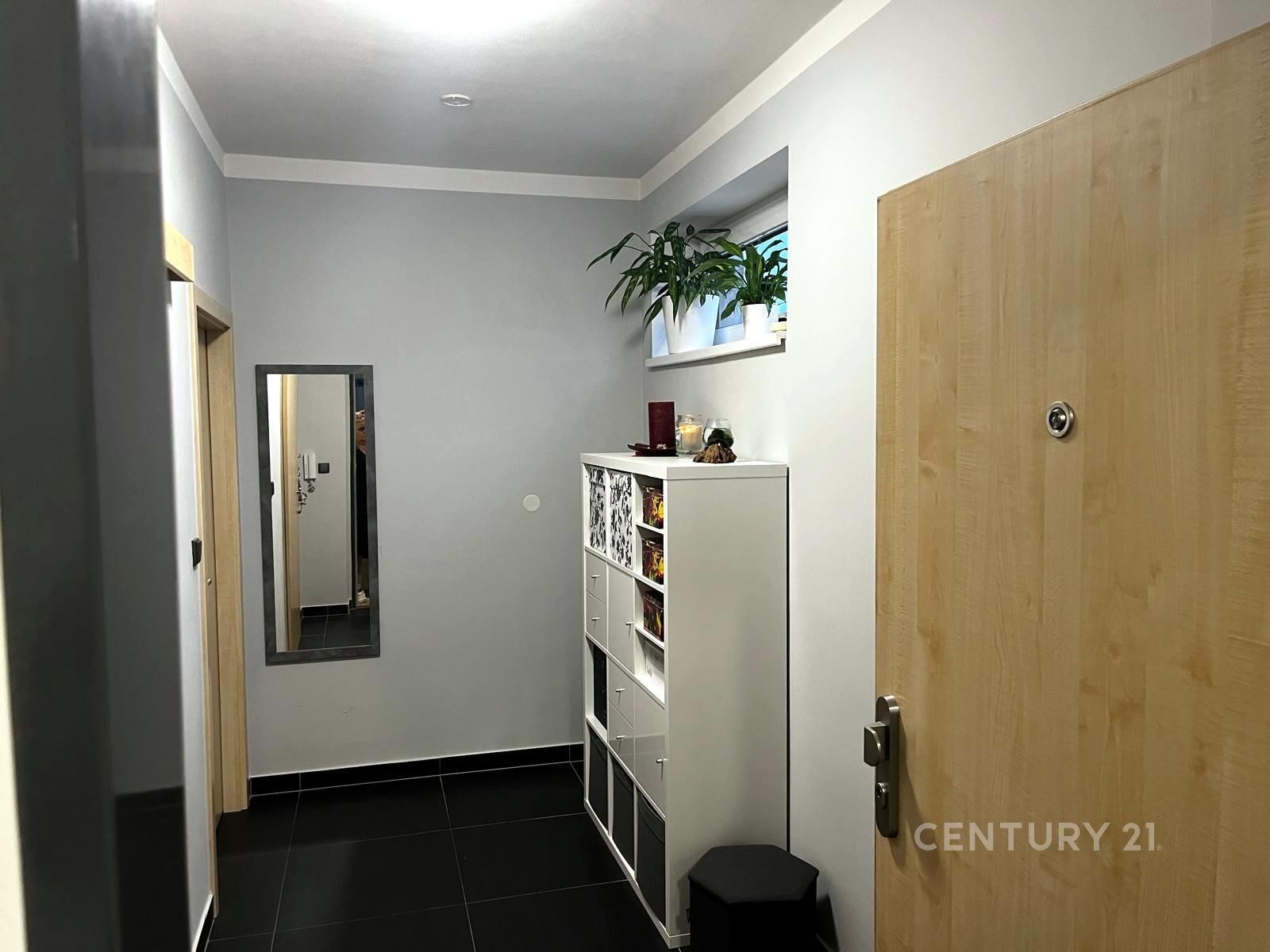 Vstupní hala s dlažbou, bílá vestavěná skříň a zrc