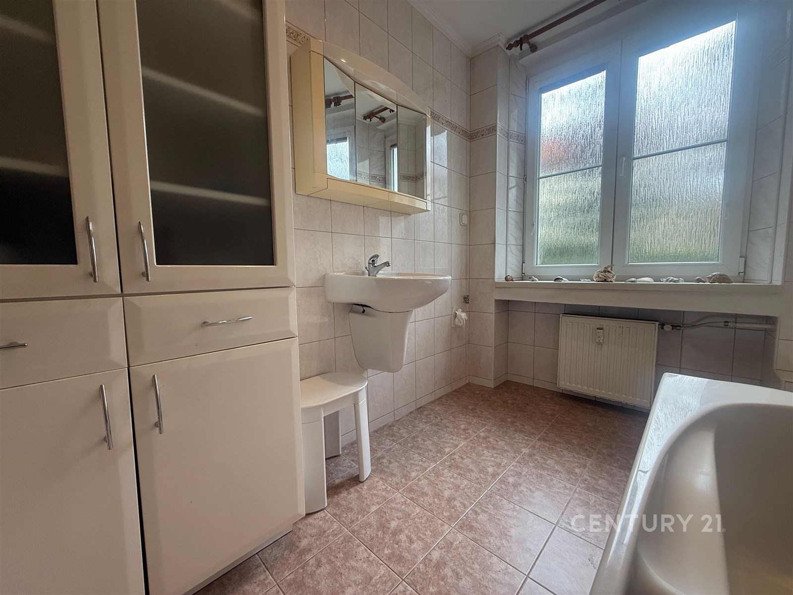 Koupelna s dlažbou a velkými okny zajišťujícími př