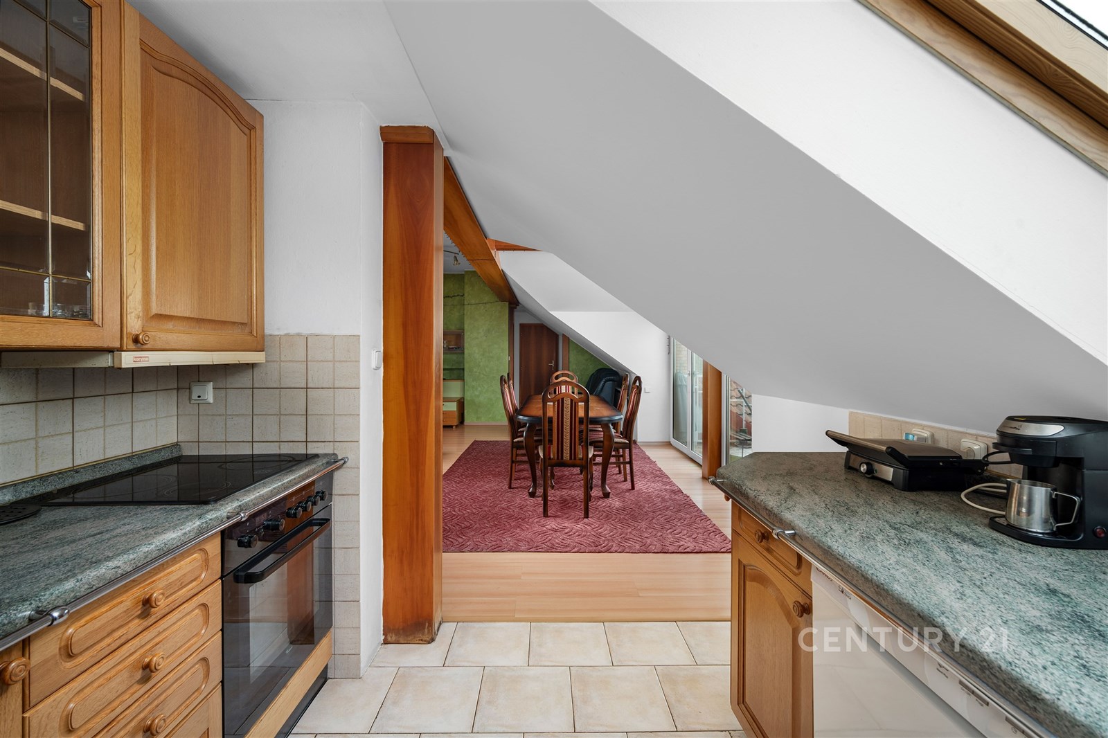 Půdní kuchyň s dlažbou, dřevěnými skříňkami a kame