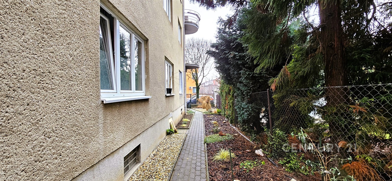 Úzká zahradní cesta se zámkovou dlažbou vedle byto