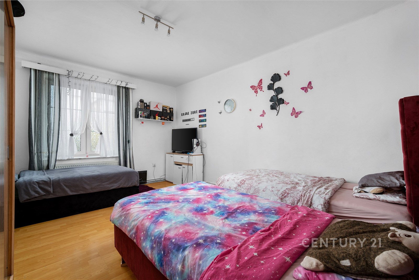 Světlá ložnice s parketovou podlahou, velkými okny