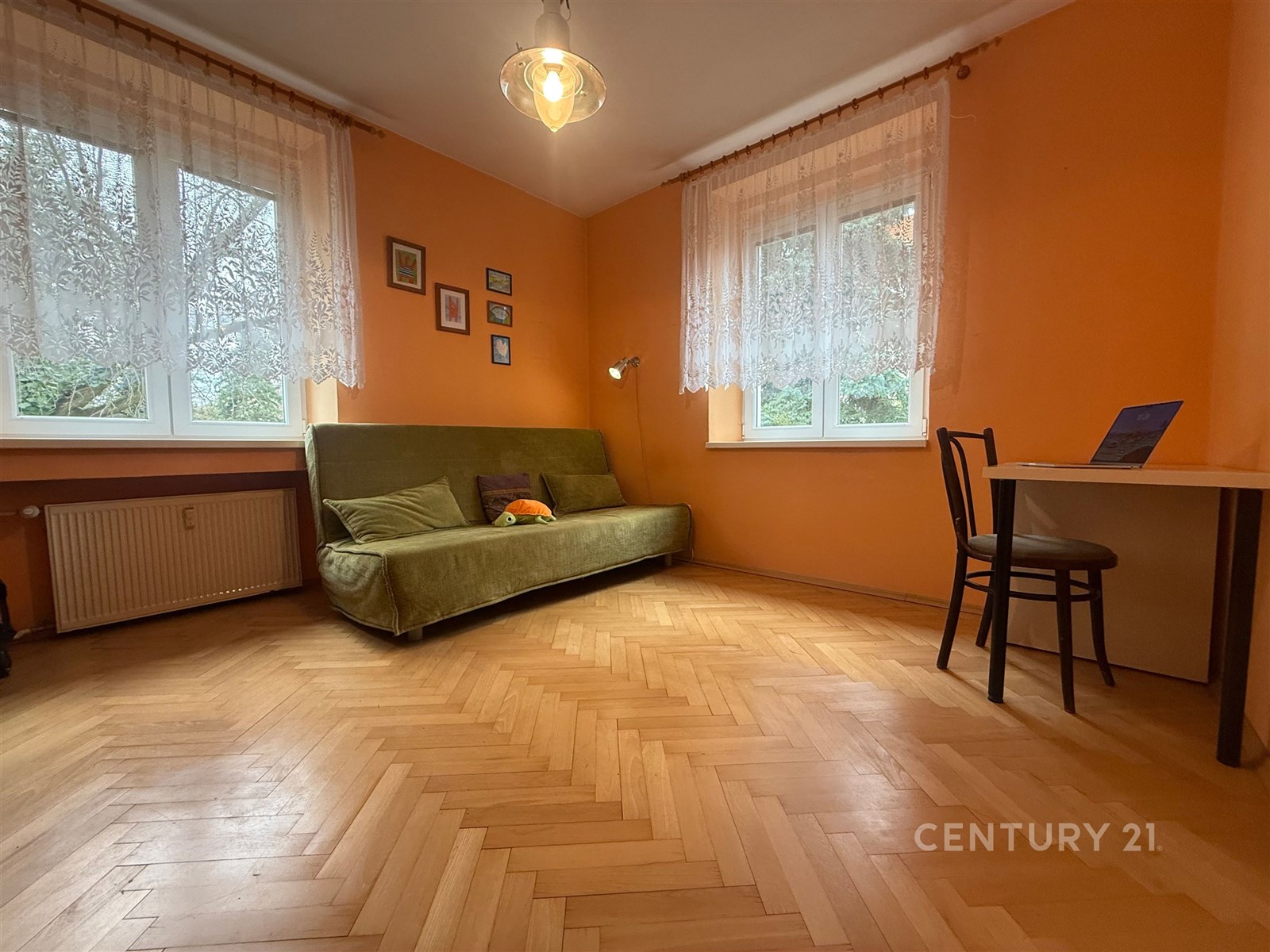 Světlý obývací pokoj s parketovou podlahou, velkým