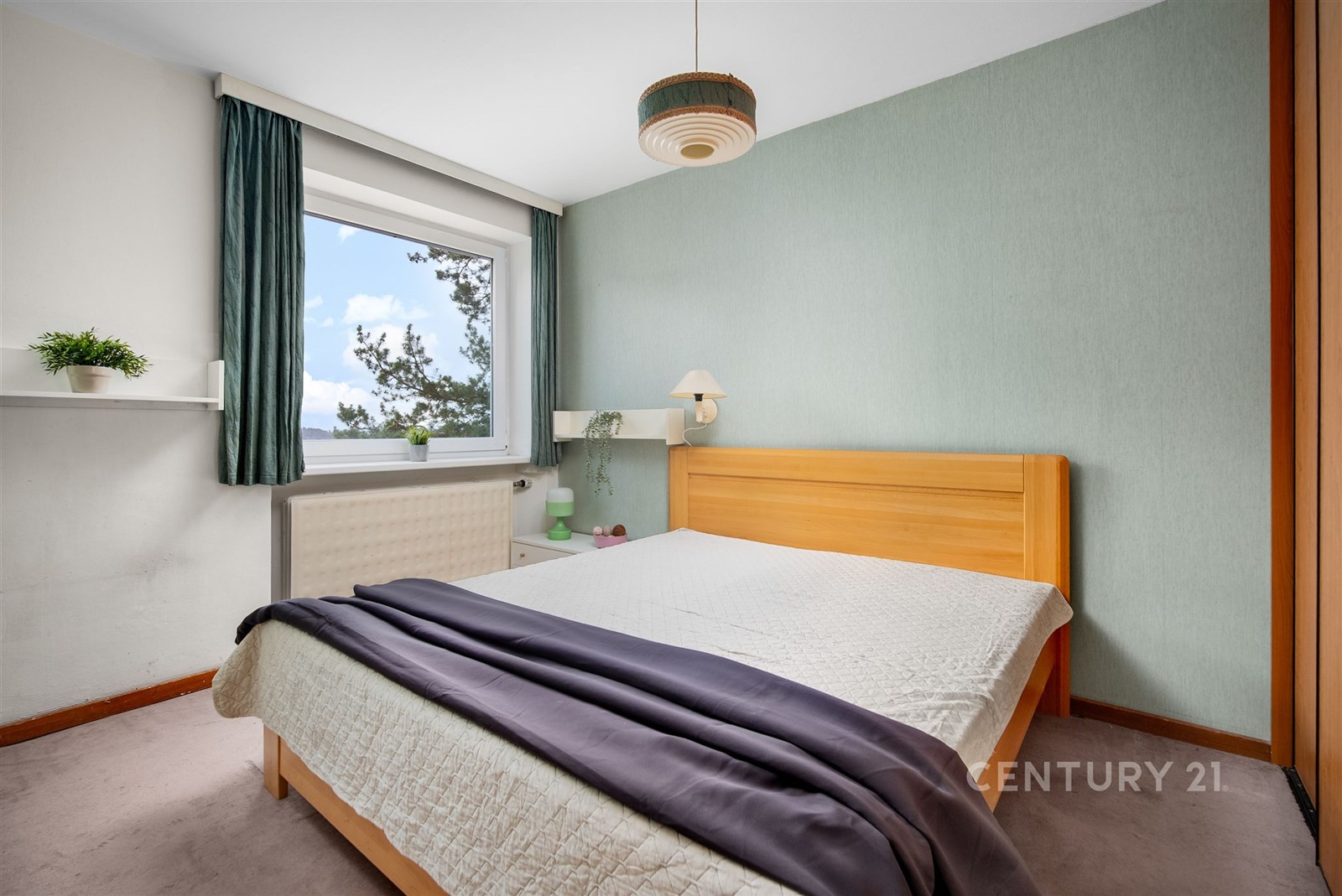 Světlá ložnice s parketovou podlahou, velkým oknem