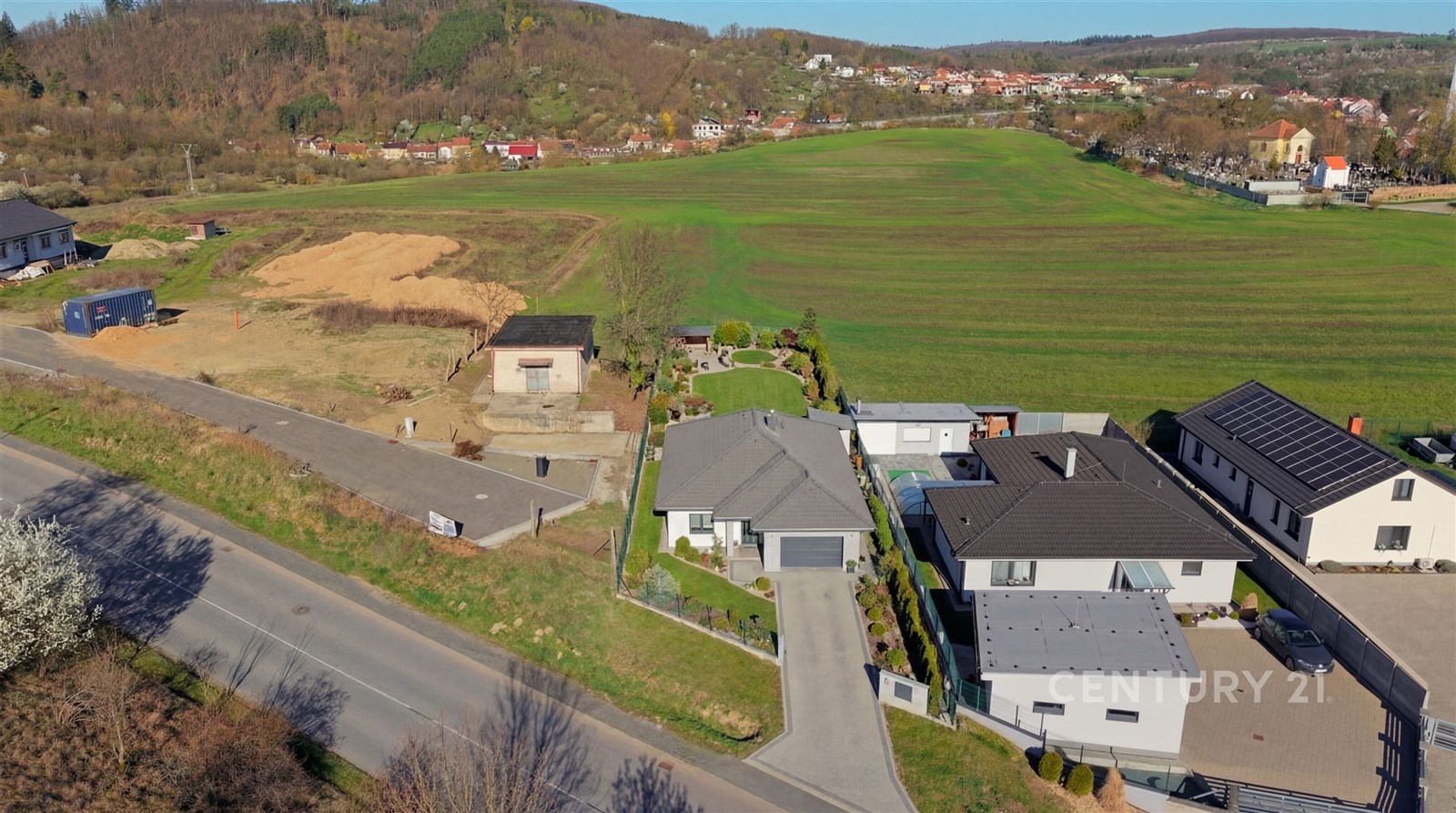 Pohled na moderní rodinný dům s velkými okny a zah