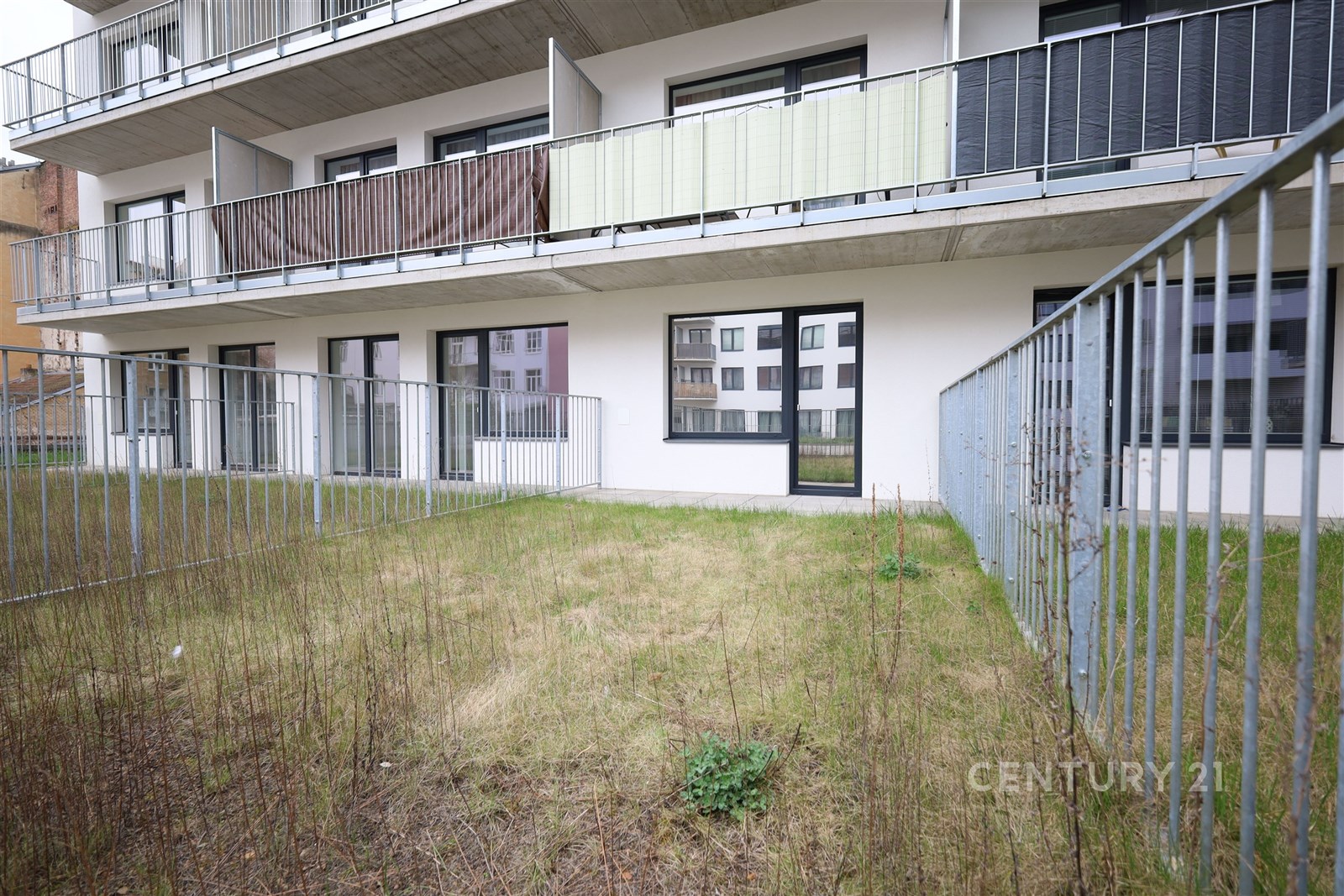 Přízemní terasa s trávníkem a moderní zábradlím, p