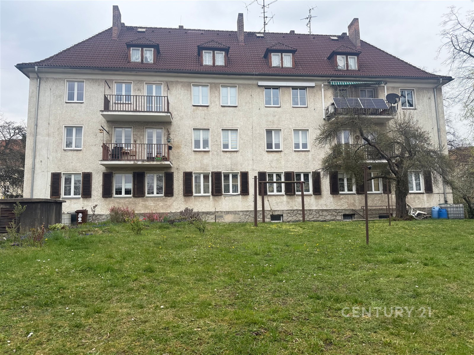 Bytový dům s původní fasádou, šikmá střecha, někol