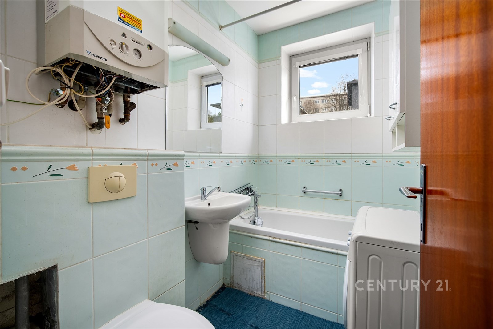 Koupelna s dlažbou a vanou, světlá díky velkým okn