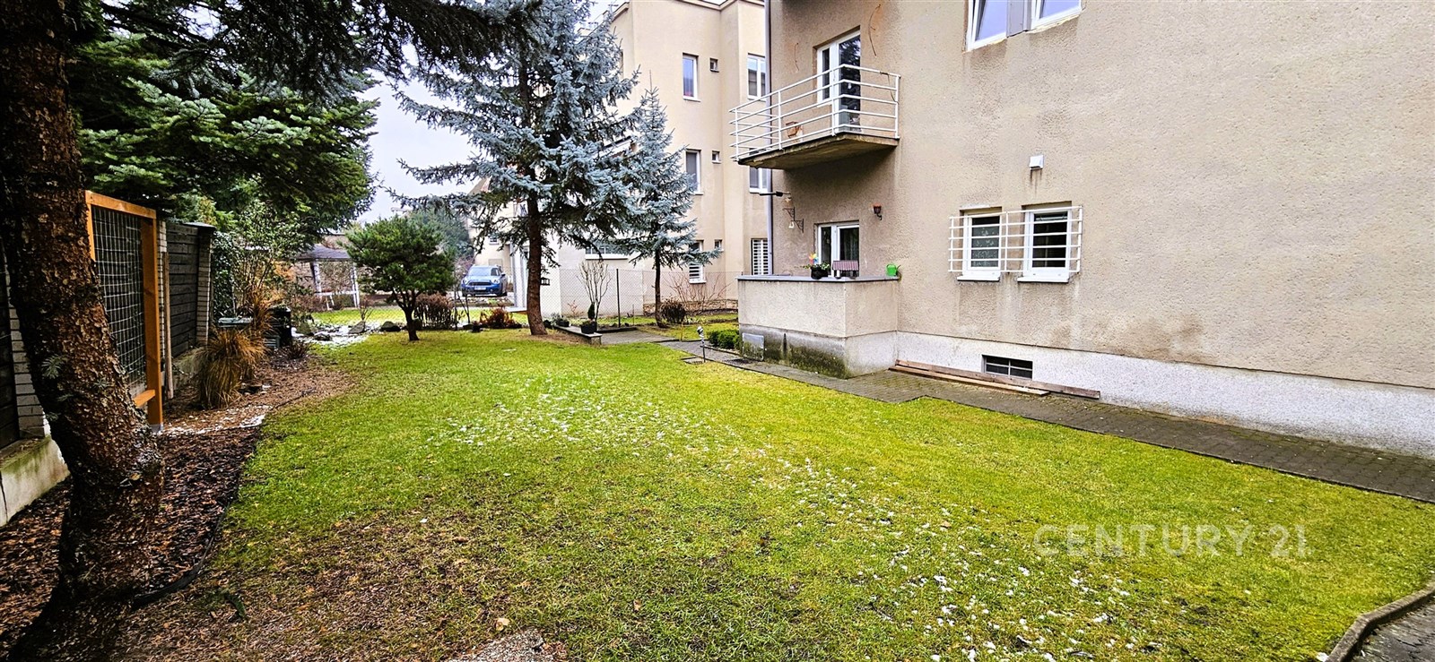 Zahrada s rovnou travnatou plochou, obklopená zást