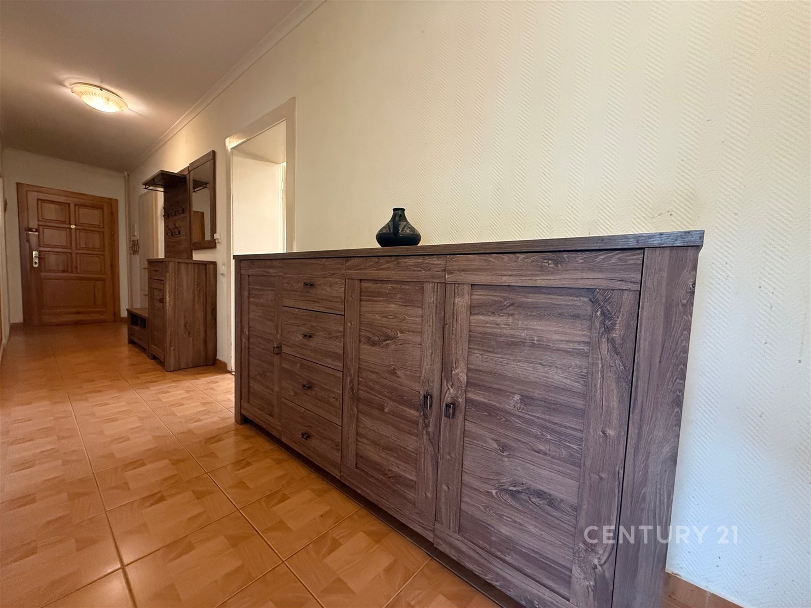 Prostorná předsíň s dřevěným nábytkem, dlažbou na 