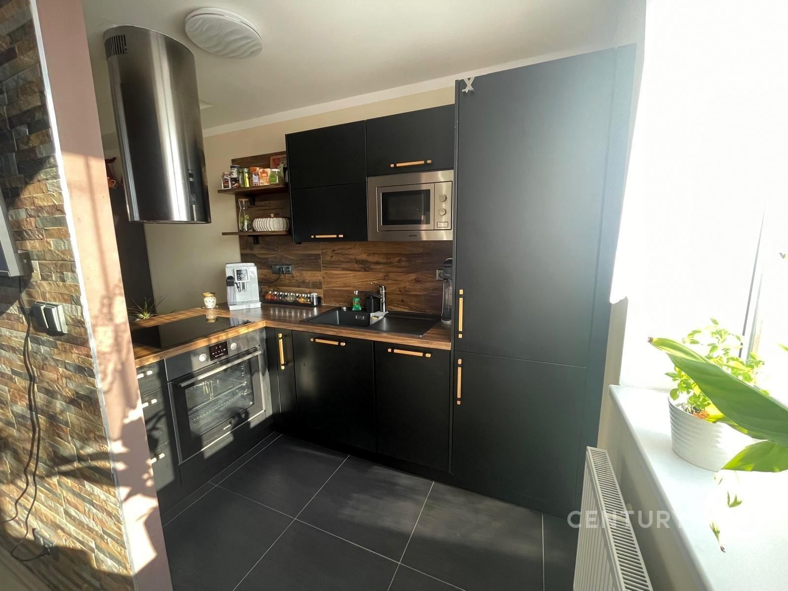 Moderní kuchyň s černými dvířky, dřevěným obložení