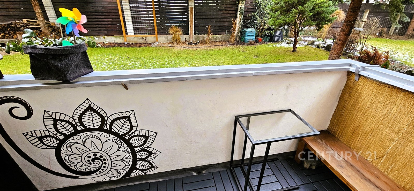 Malý balkon s dřevěnou podlahou, zdobený mandalou 