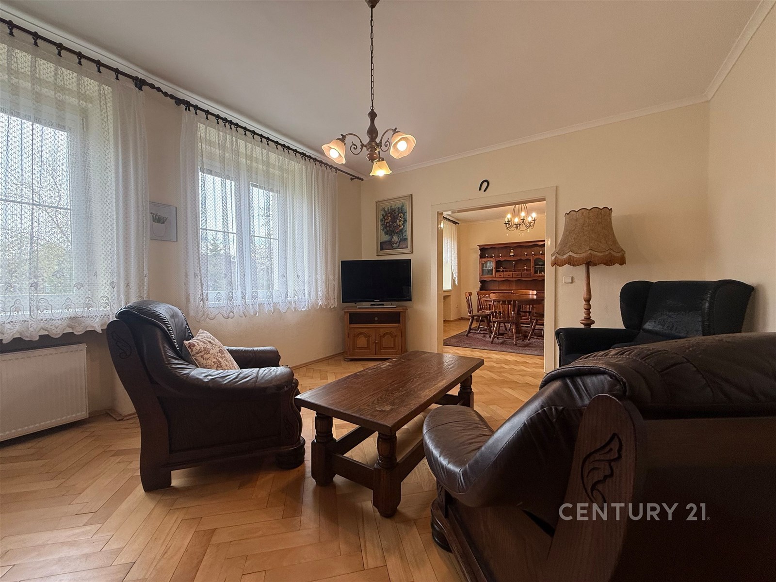 Světlý obývací pokoj s parketovou podlahou, velkým