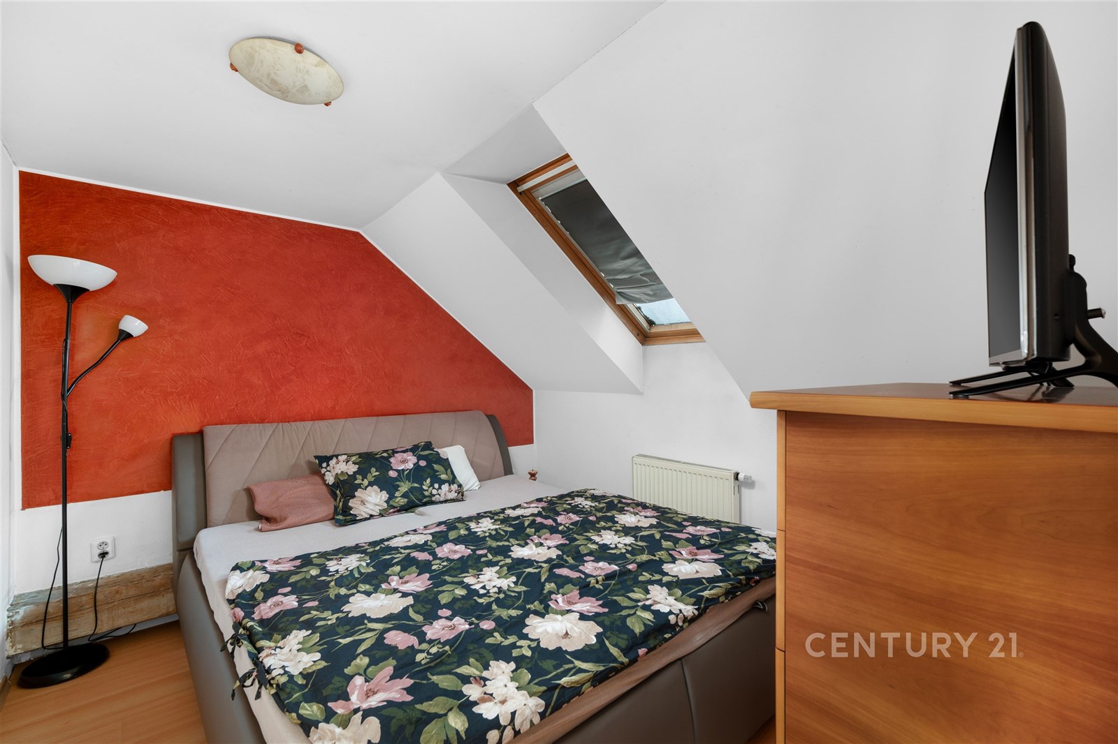 Podkrovní ložnice s dřevěnou podlahou, velkým stře