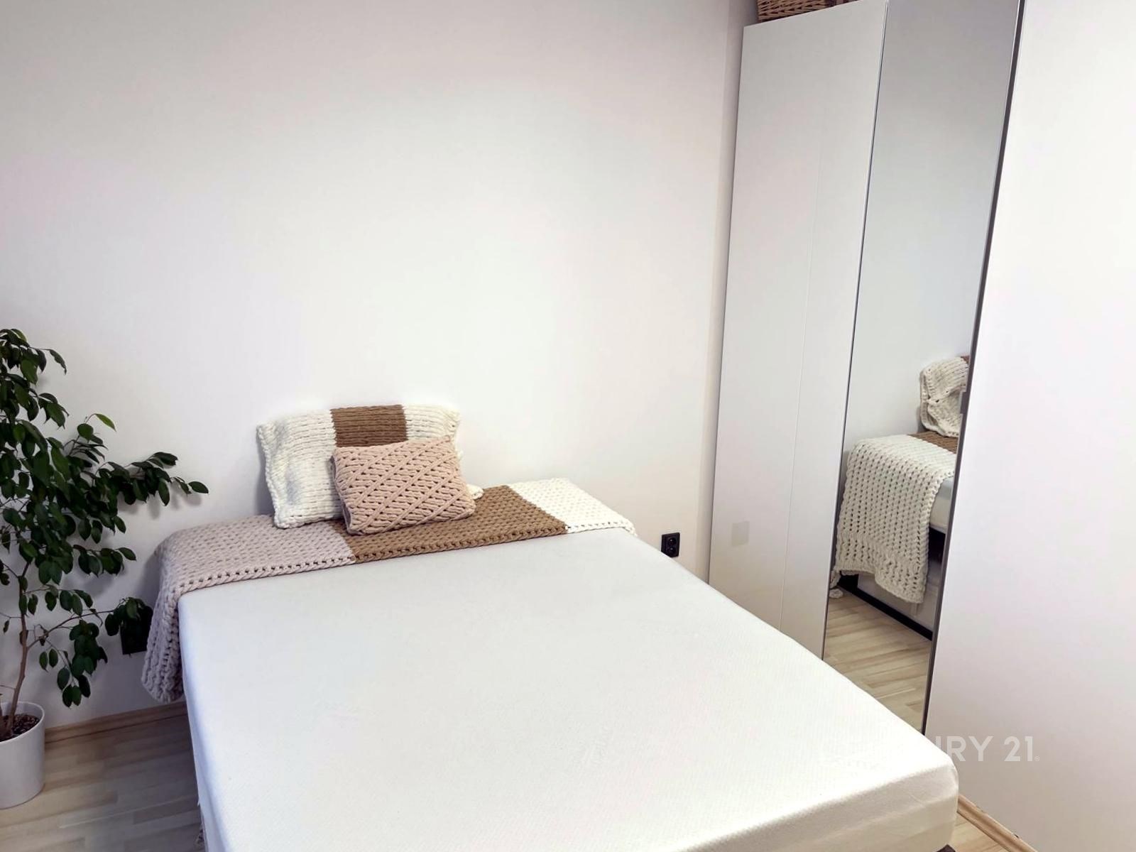 Světlá ložnice s parketovou podlahou, vestavěnými 