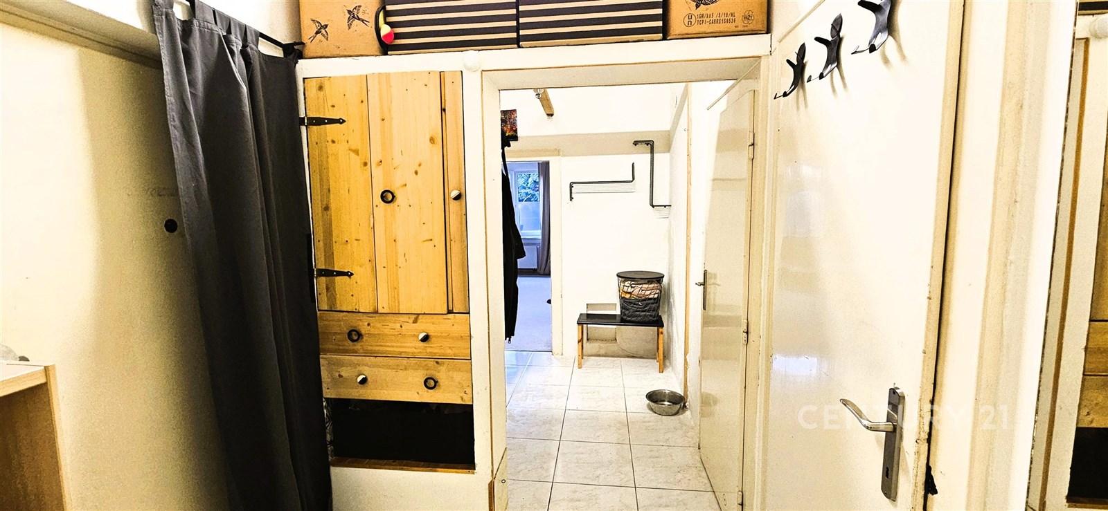 Chodba s dlažbou, dřevěnými úložnými prostory a bí