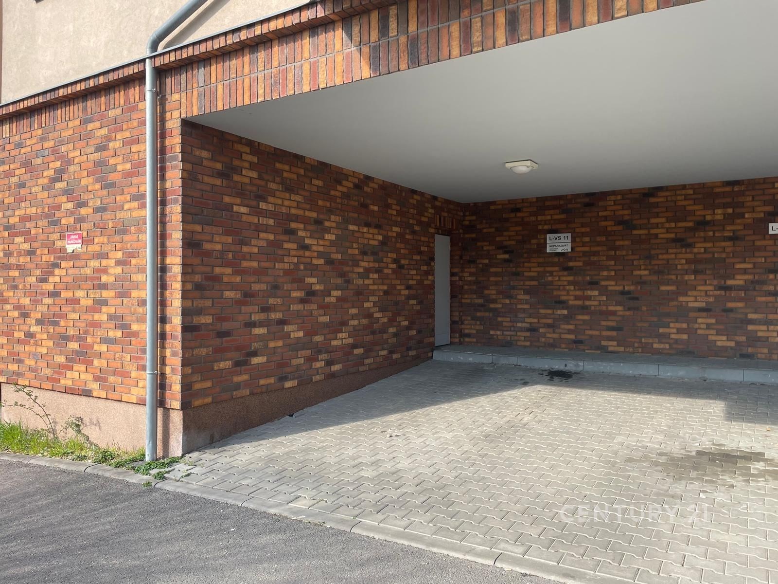 Krytý parkovací prostor s cihlovými zdmi, dlažba n