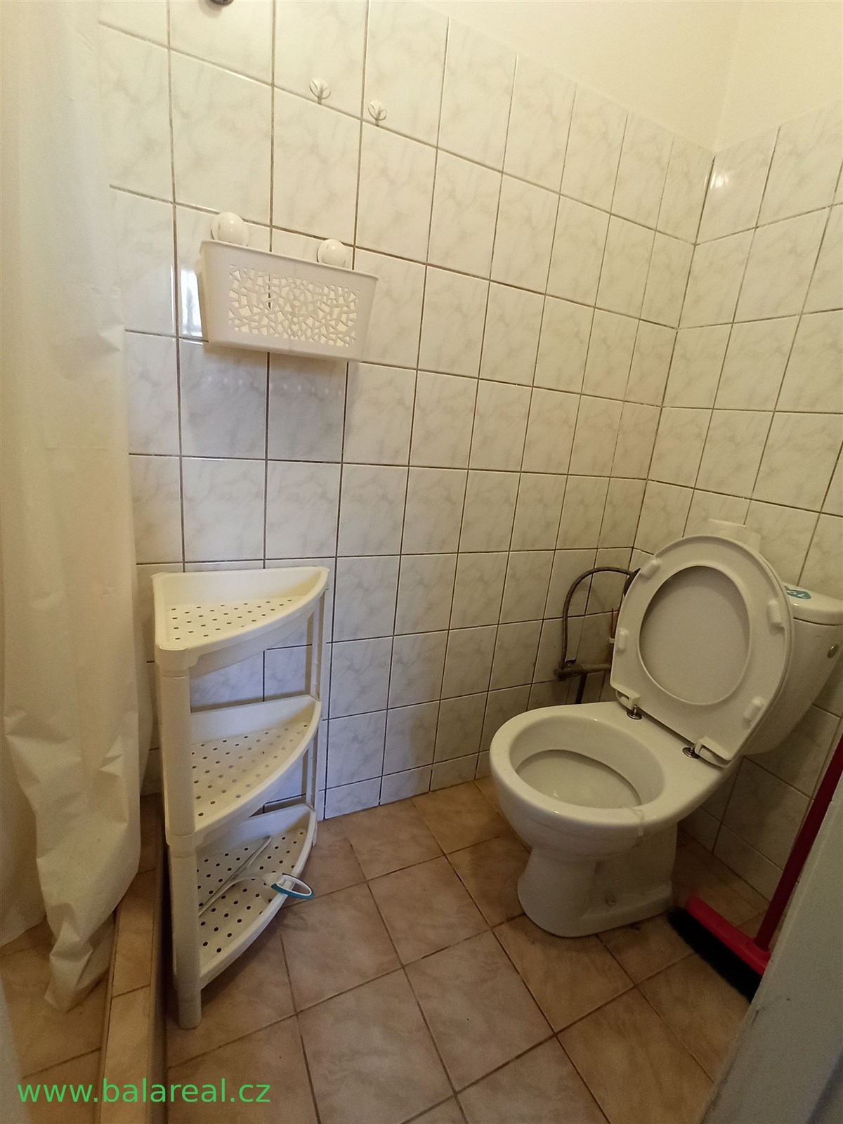 Koupelna s dlažbou a obklady, vybavená toaletou a 