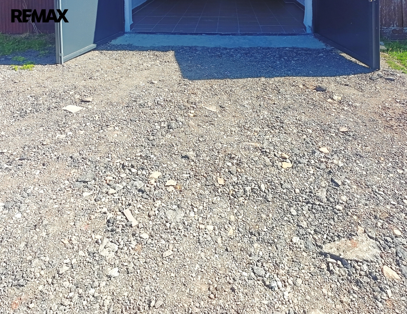 Před garáží je nový hrubý štěrk.