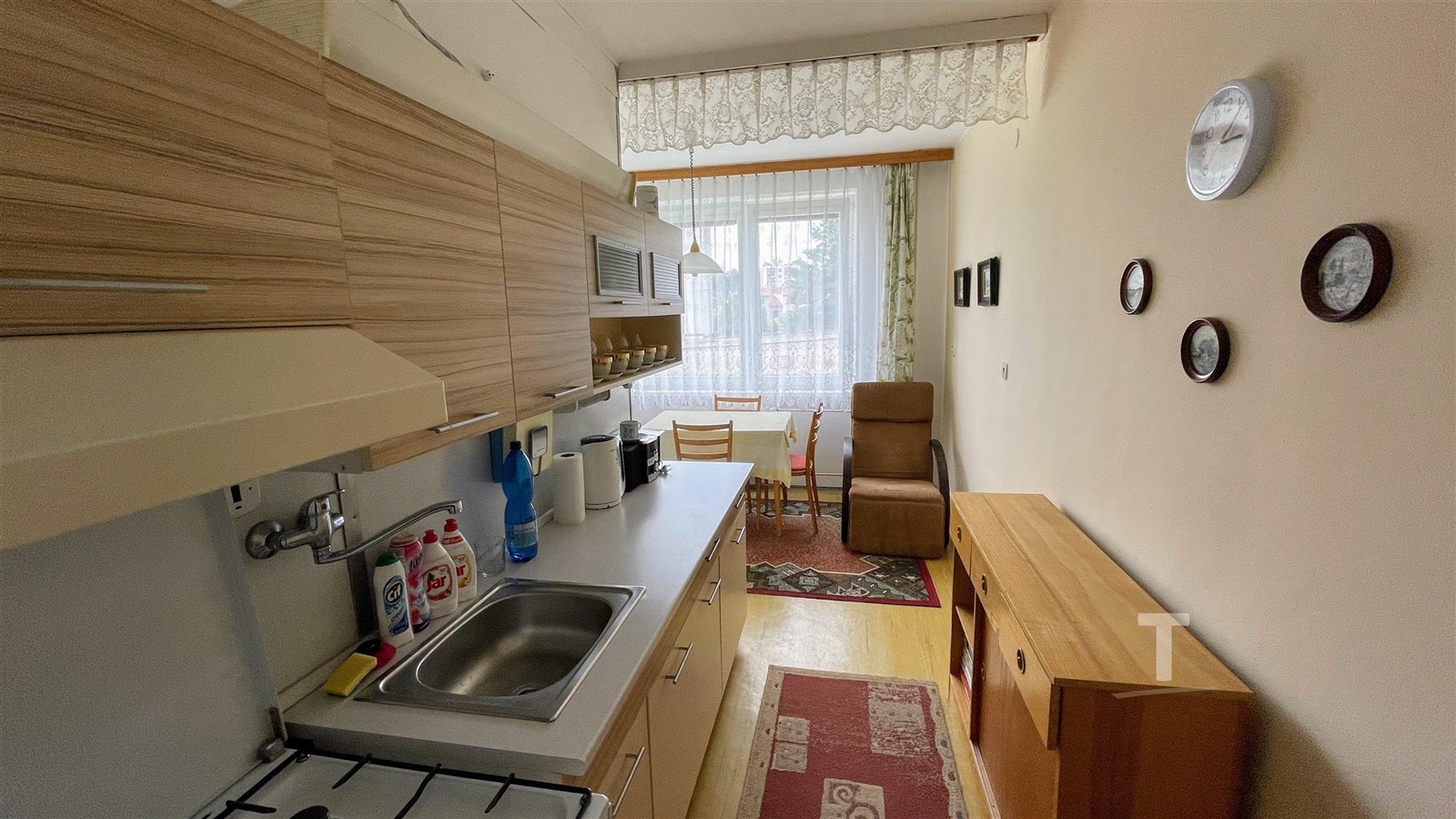 Útulná kuchyň s dřevěnými skříňkami, laminátovou p