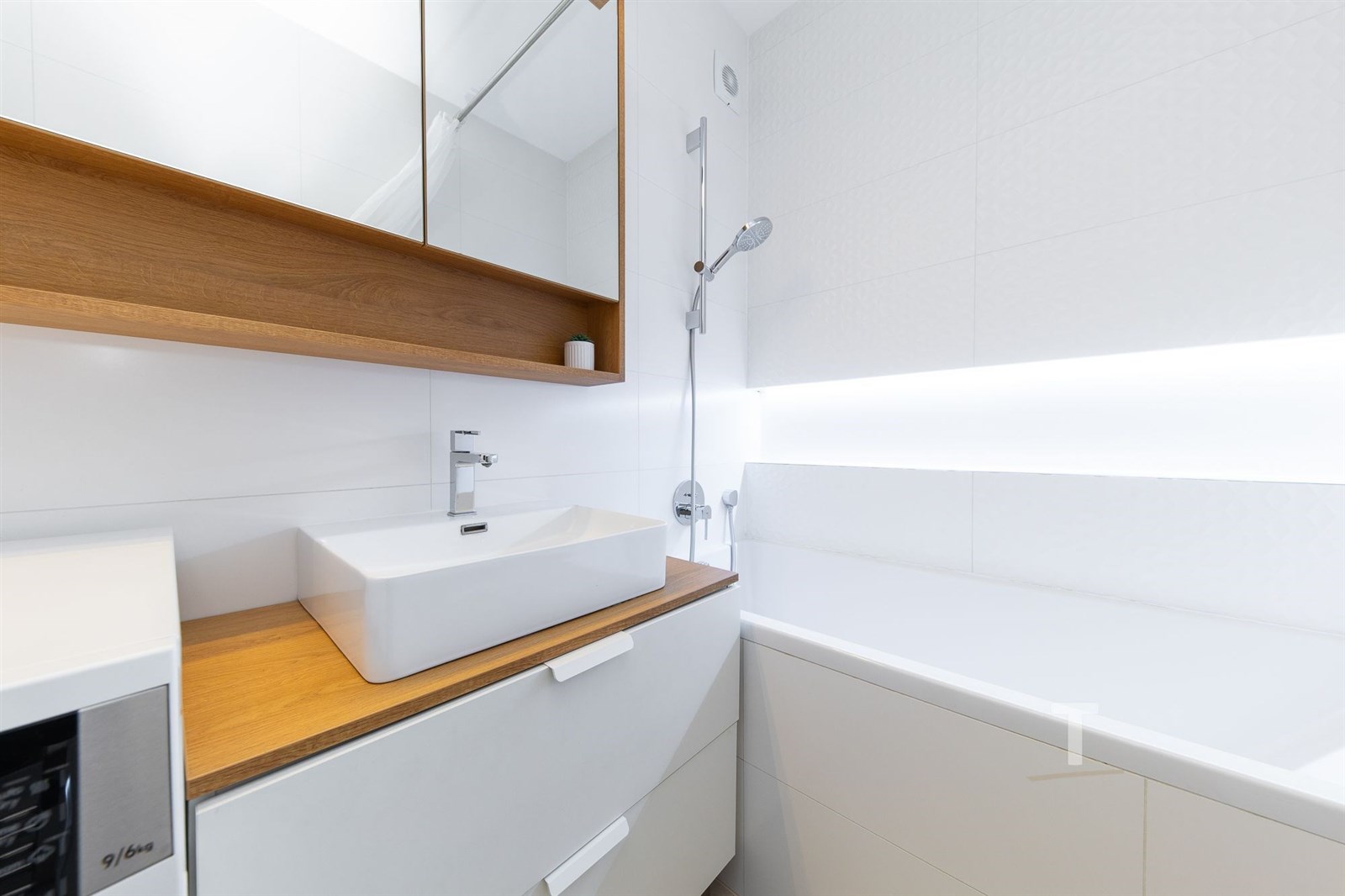 Moderní koupelna s bílými obklady, stylovým umyvad