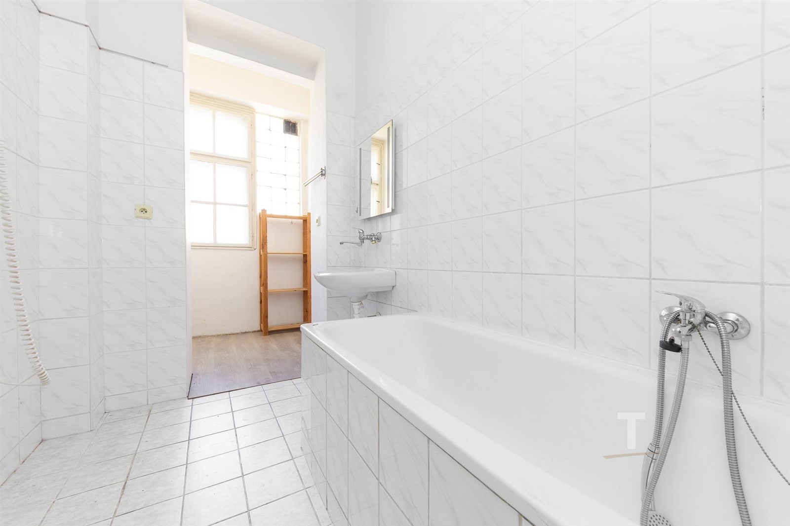 Prostorná koupelna s bílou dlažbou, světlé obklady