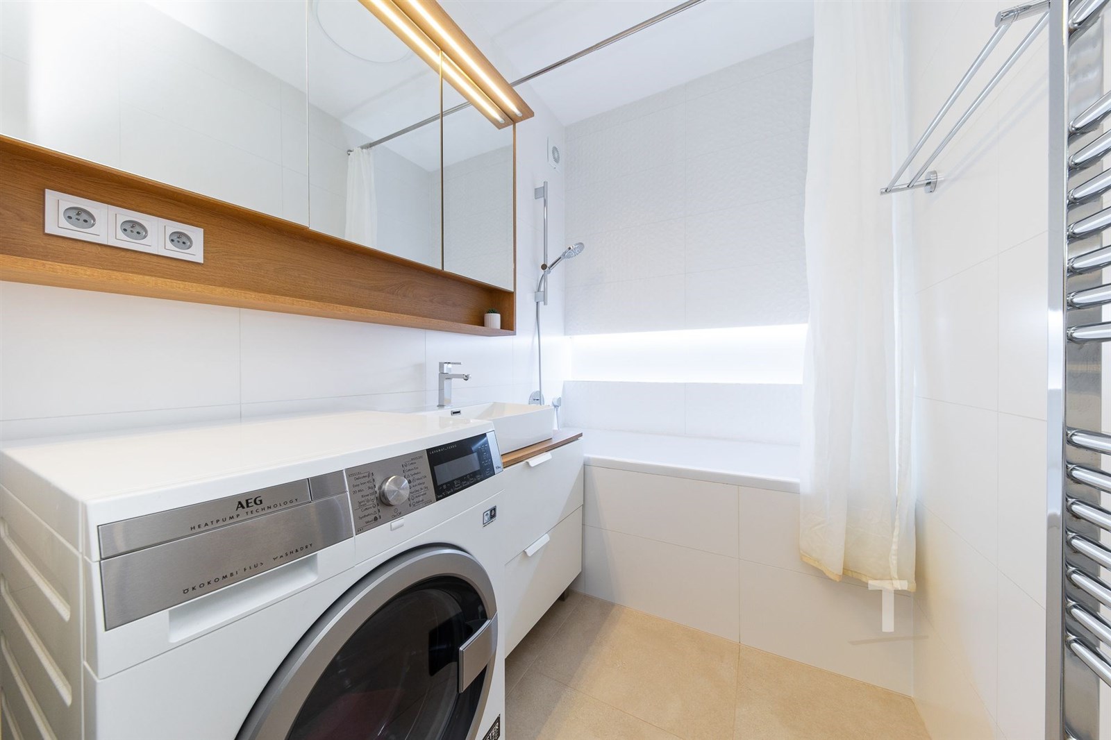 Koupelna s moderní pračkou, světlá dlažba, velké z