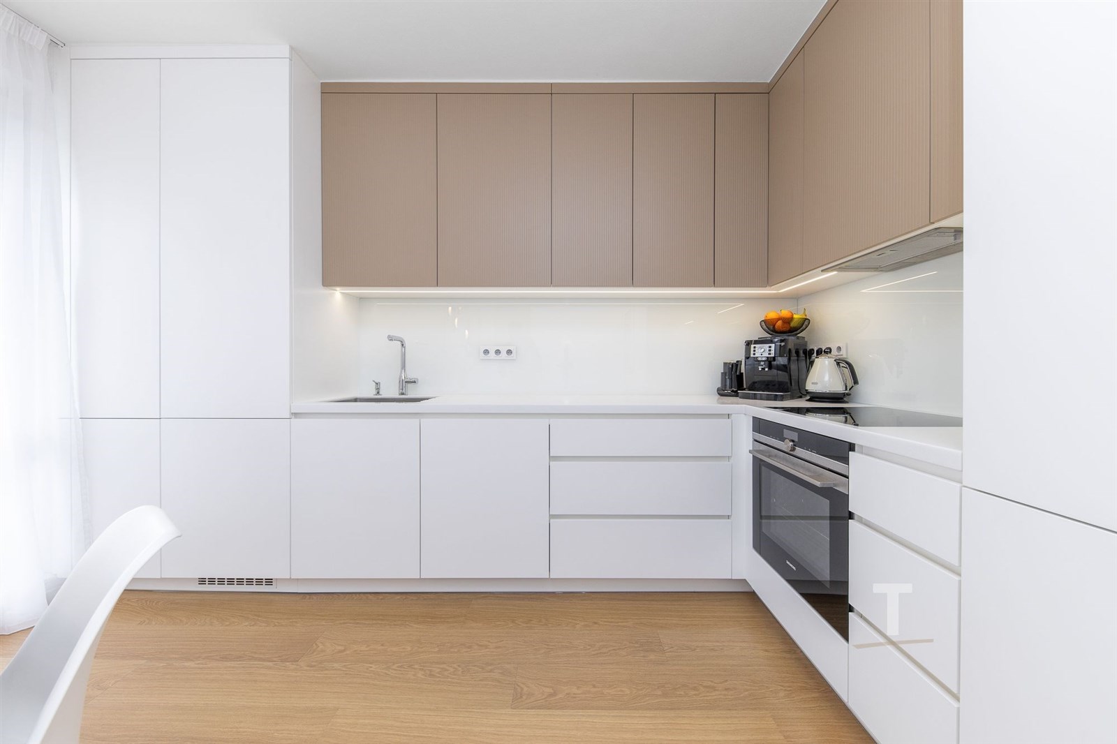 Moderní kuchyň s bílými skříňkami, dřevěnou podlah