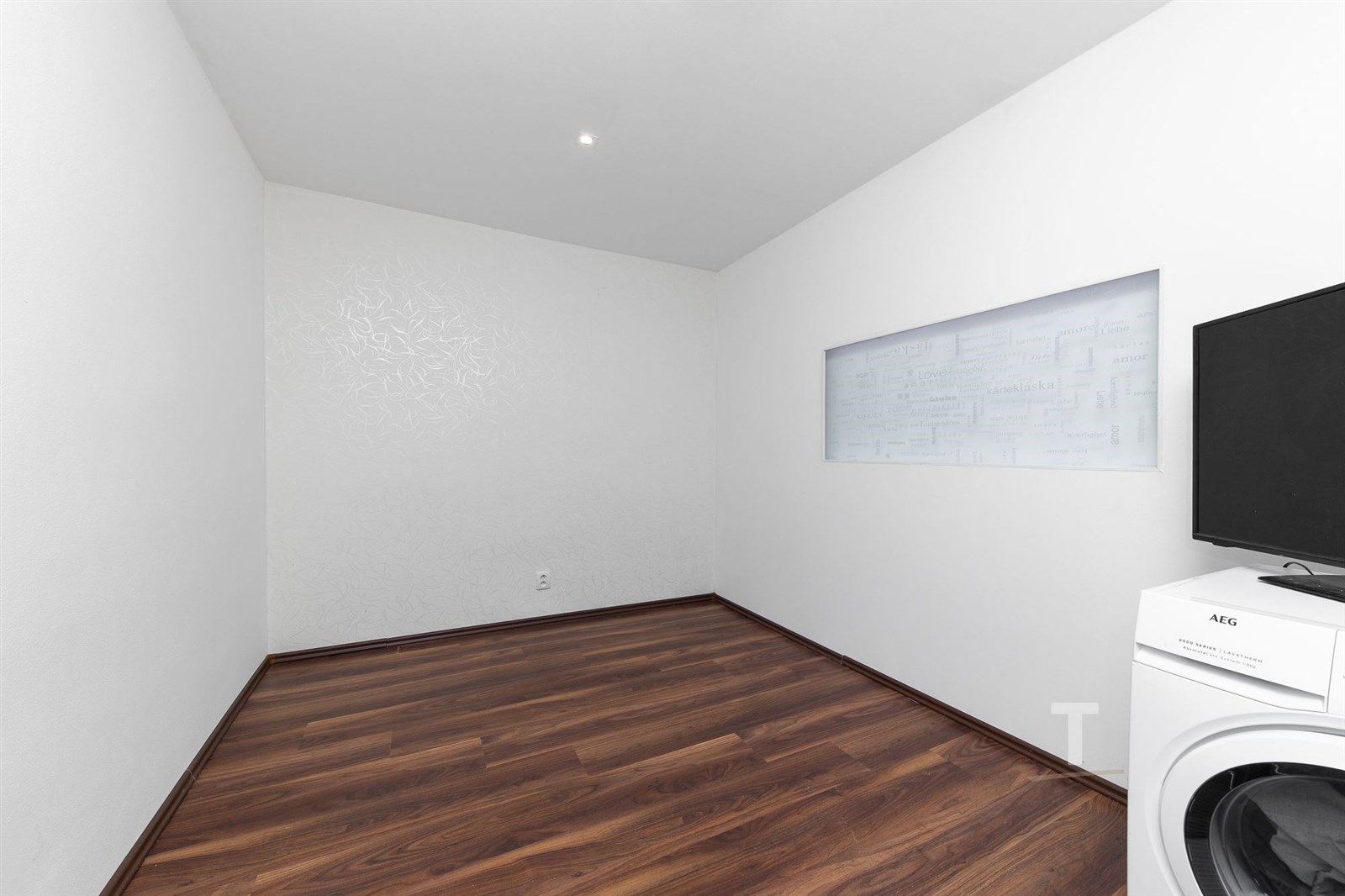 Prázdný pokoj s parketovou podlahou, bílými stěnam