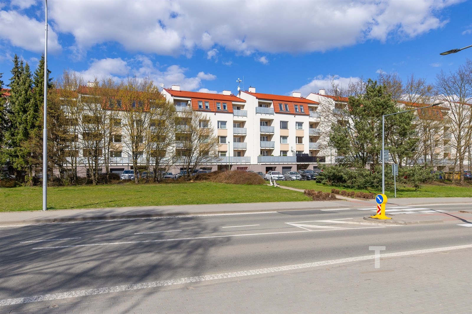 Nízkopodlažní bytový komplex s červenou střechou, 