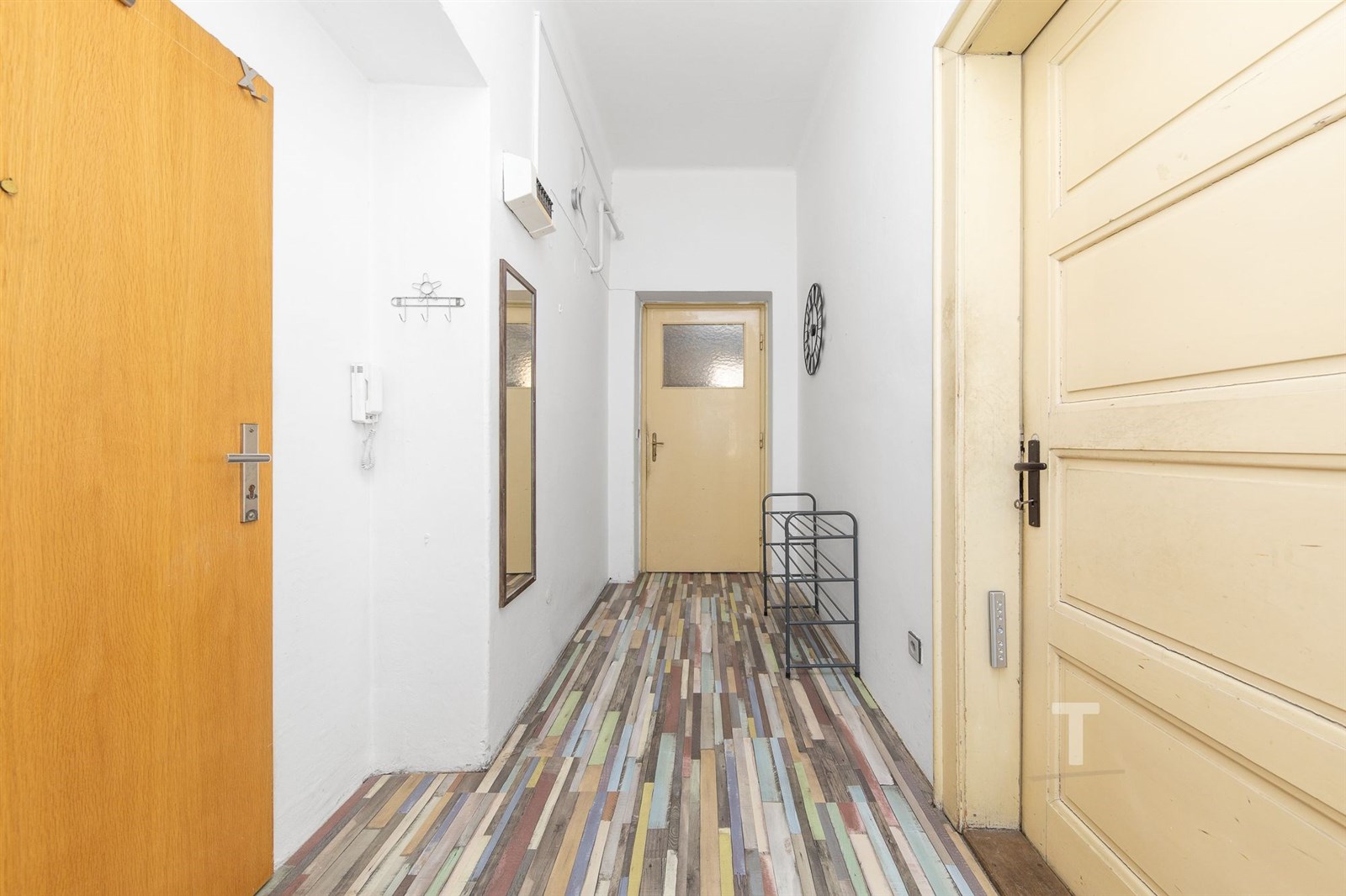 Předsíň s barevnou laminátovou podlahou, bílými st