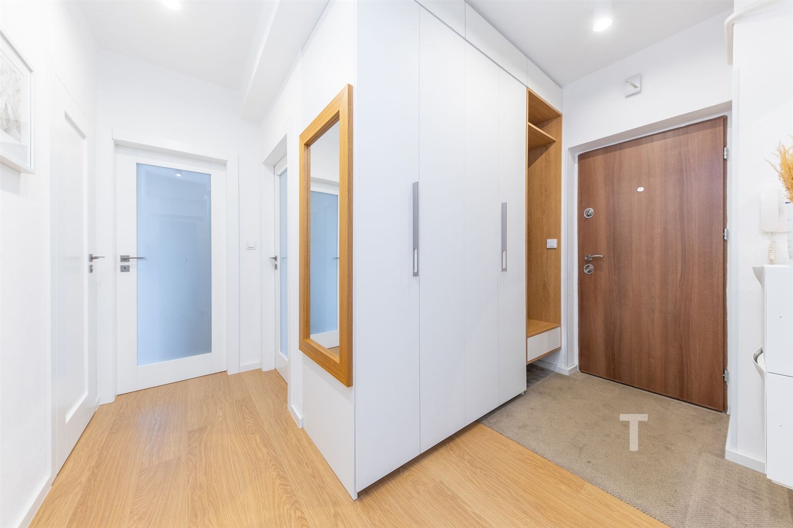 Vstupní hala s dřevěnou podlahou, vestavěnými skří