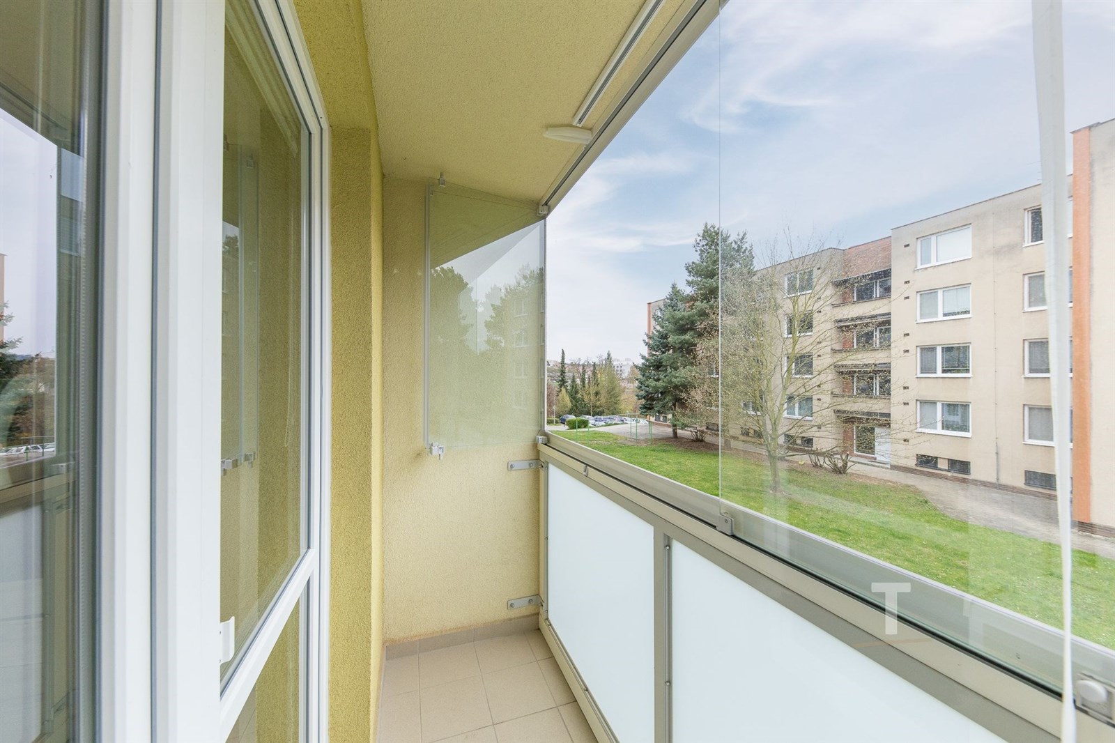 Zasklený balkon s dlažbou, moderní úprava, výhled 