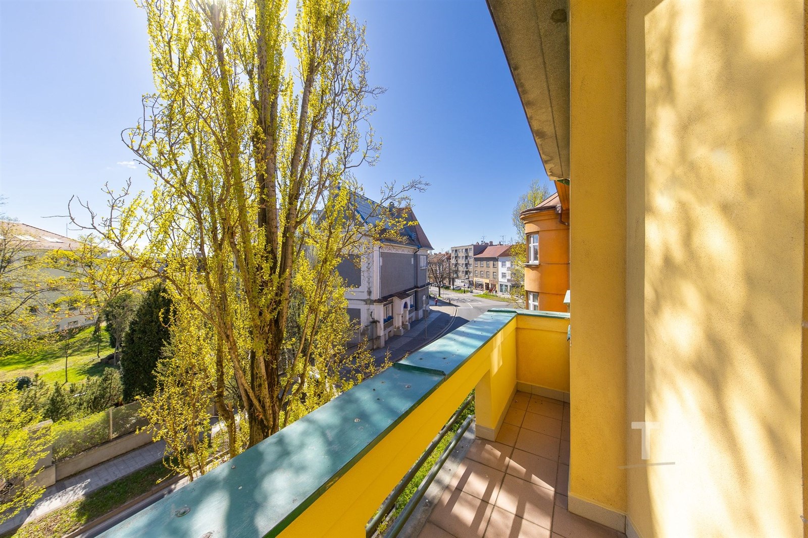 Balkon s dlažbou nabízí výhled na městskou krajinu