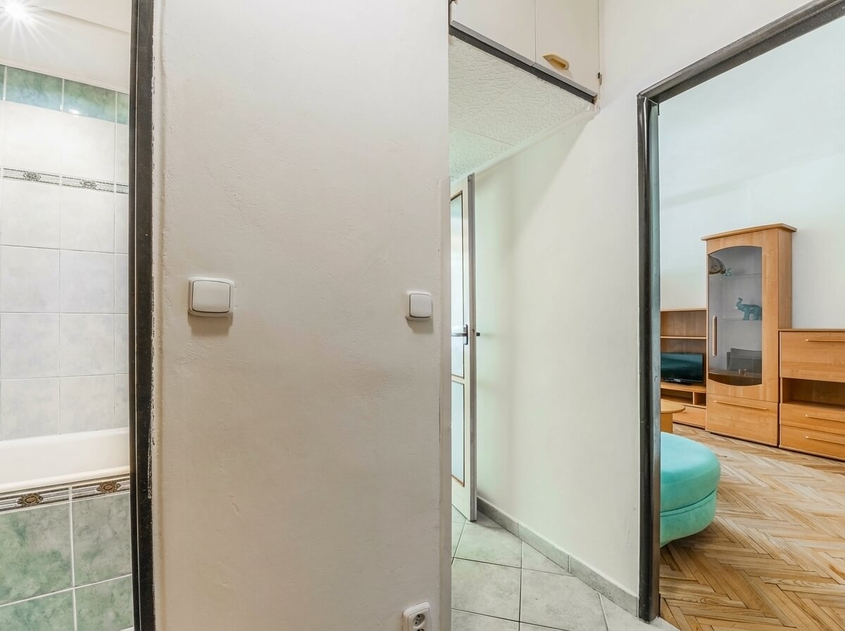 Předsíň s dlažbou, vstupem do koupelny a obýváku; 