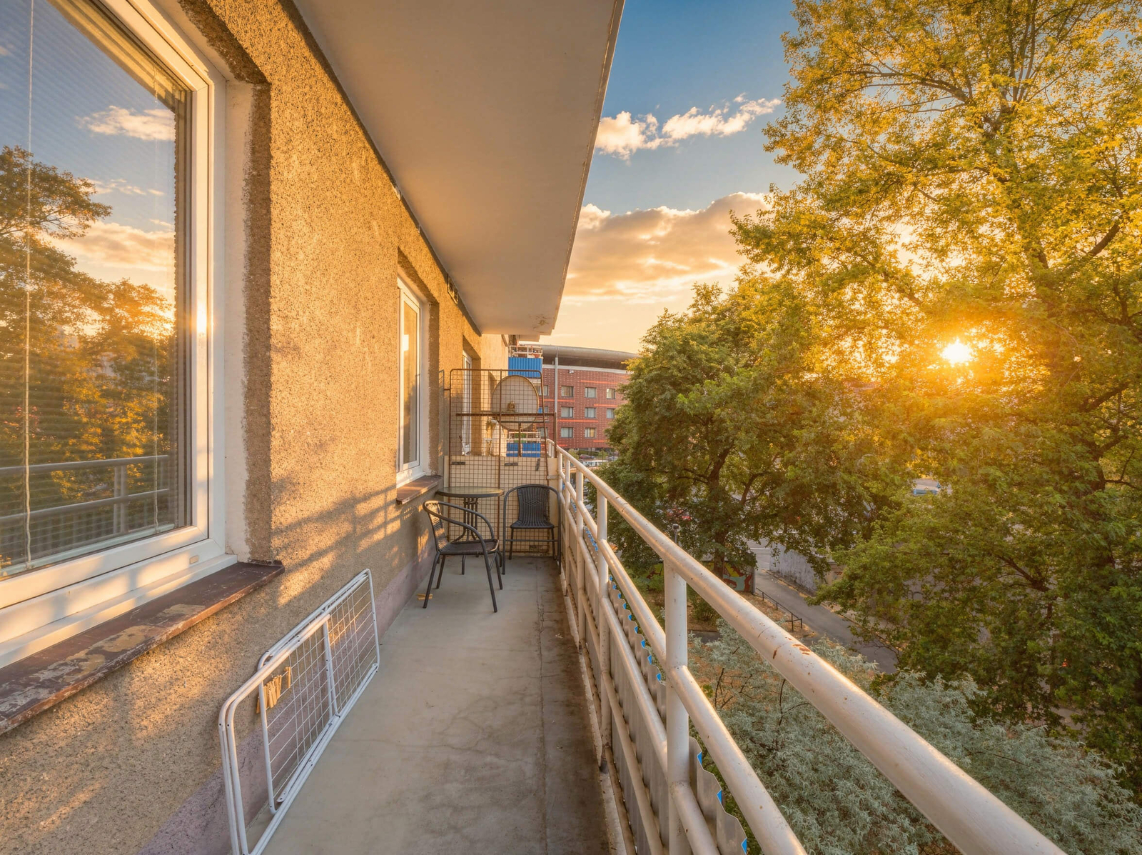 Podlouhlý balkon obklopený korunami stromů; dostat