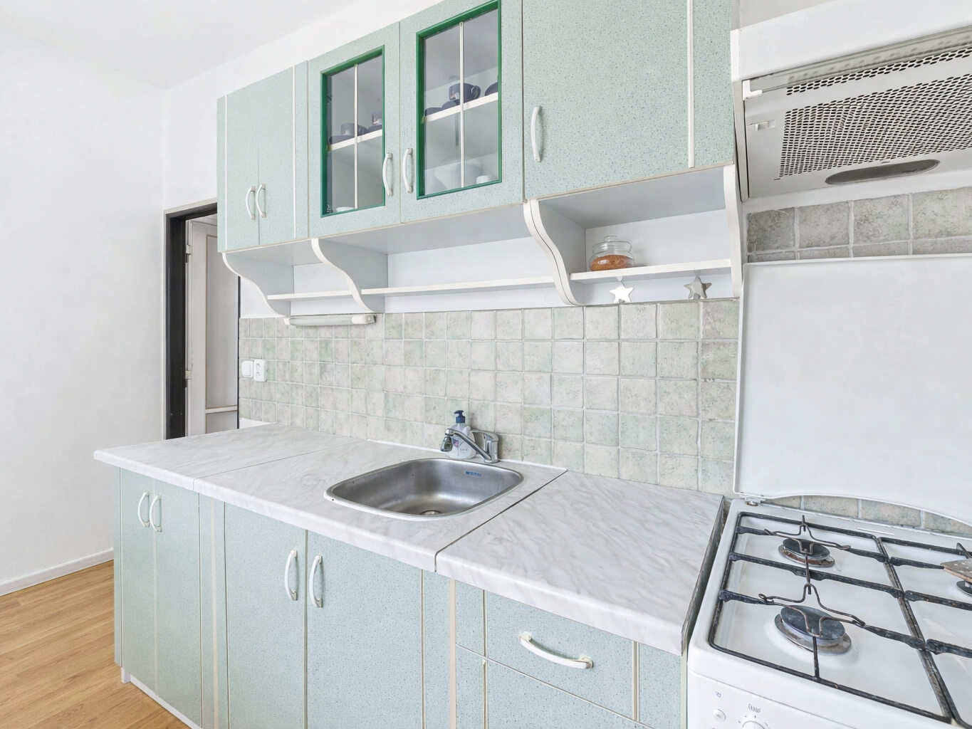 Detail kuchyňské linky se dřezem, plynovým sporáke