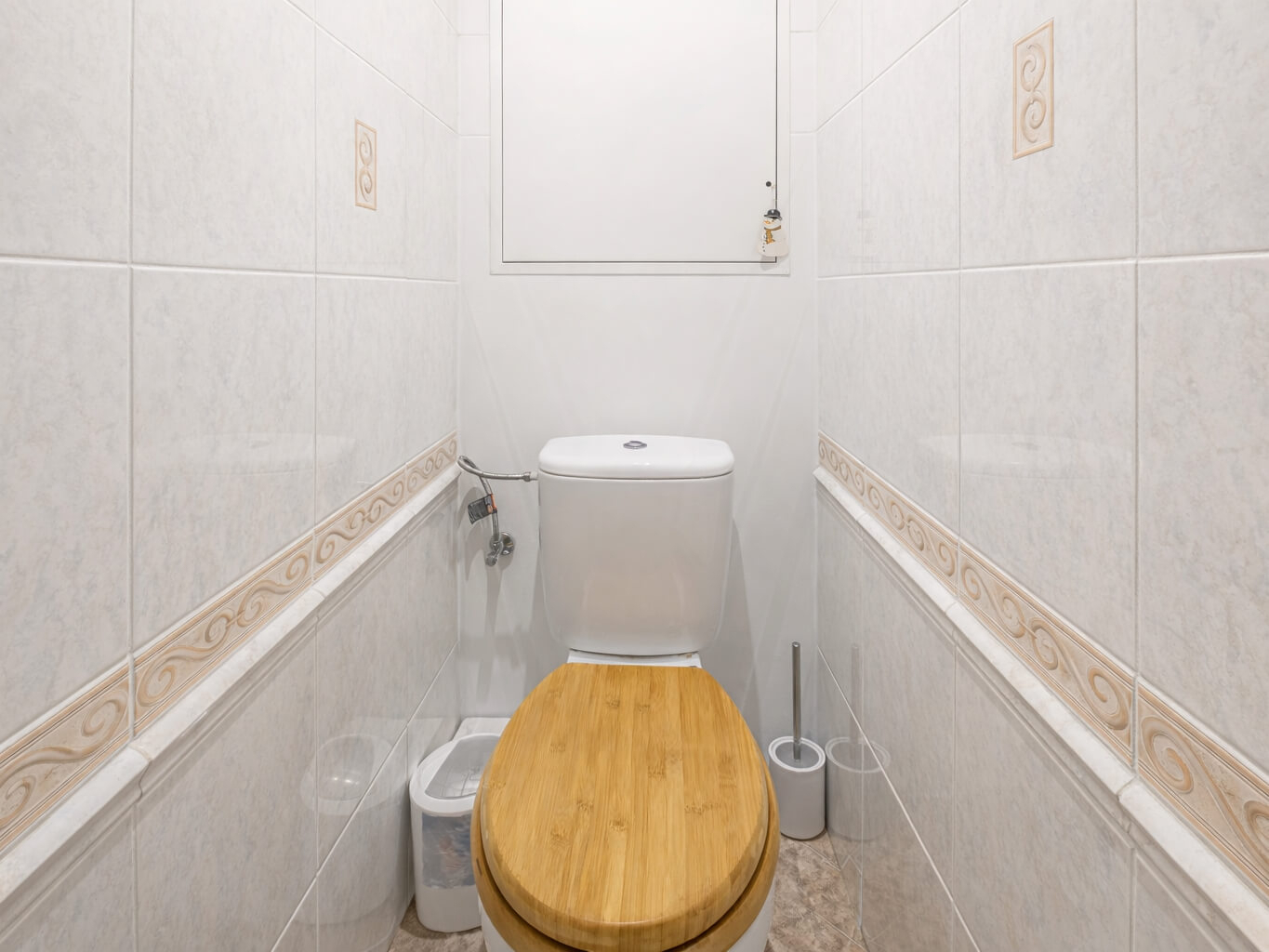 Samostatné WC s dřevěným prkénkem a světlým obklad