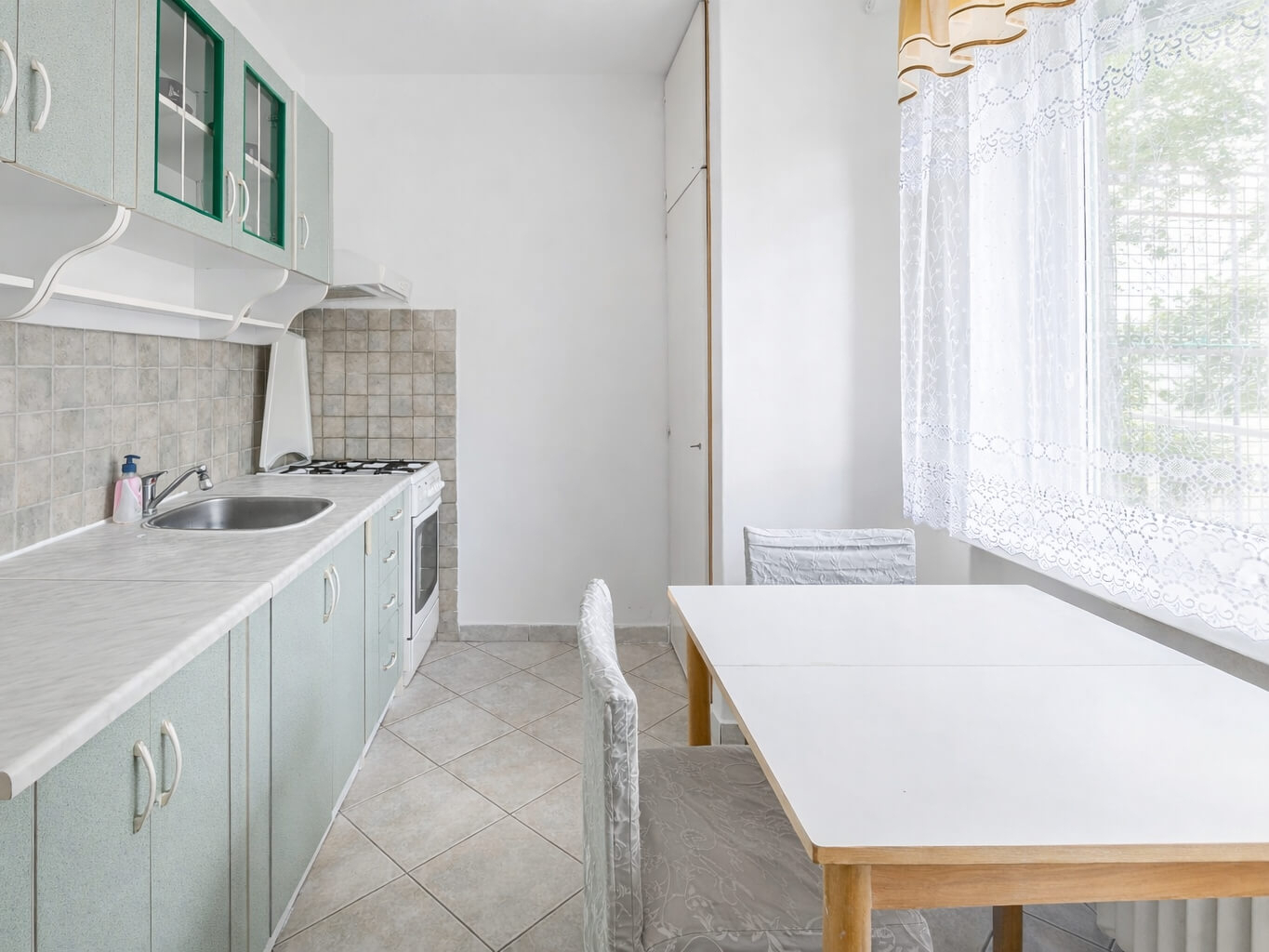 Světlá kuchyně s oknem do zeleně, plynovým sporáke