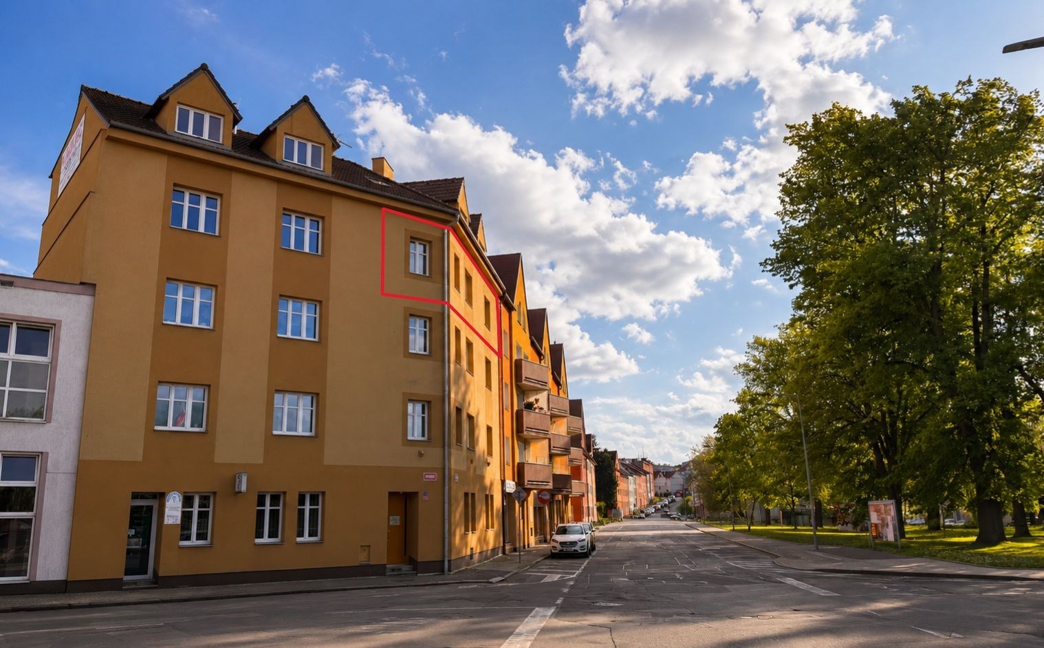 Žlutá činžovní budova s renovovanou fasádou, dvojitá okna, klidná lokalita poblíž centra, dostupné parkování na ulici