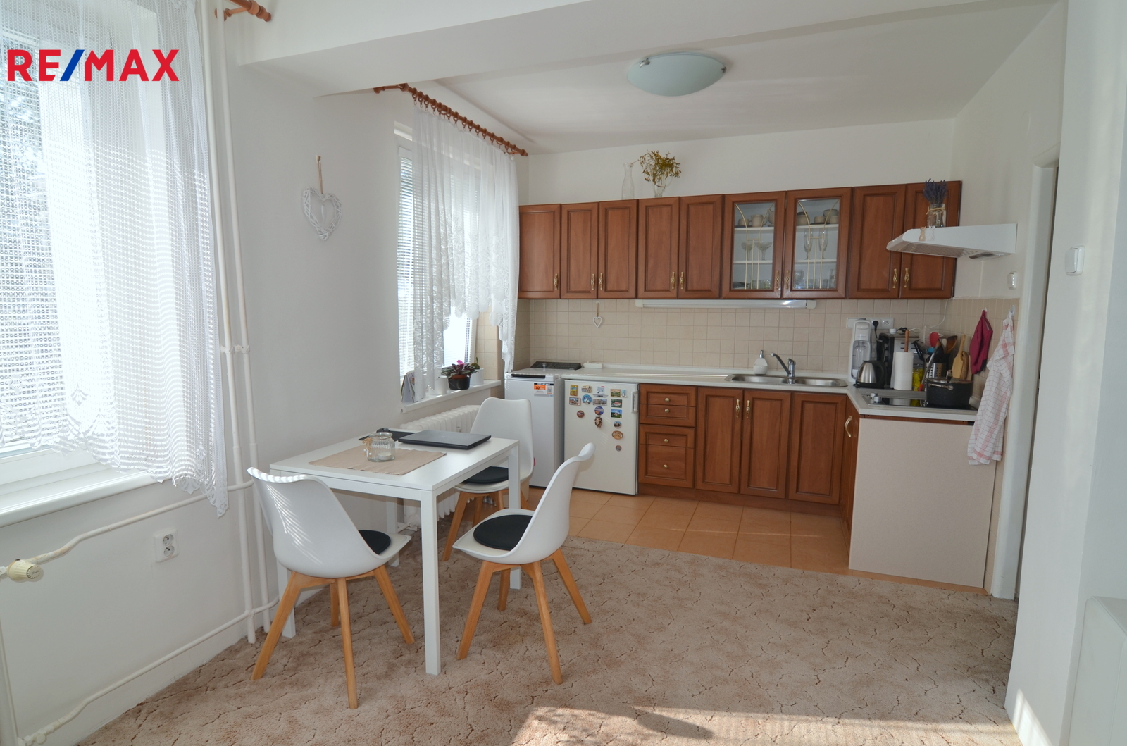 pohled na kuchyňský kout a jídelní stůl se třemi ž