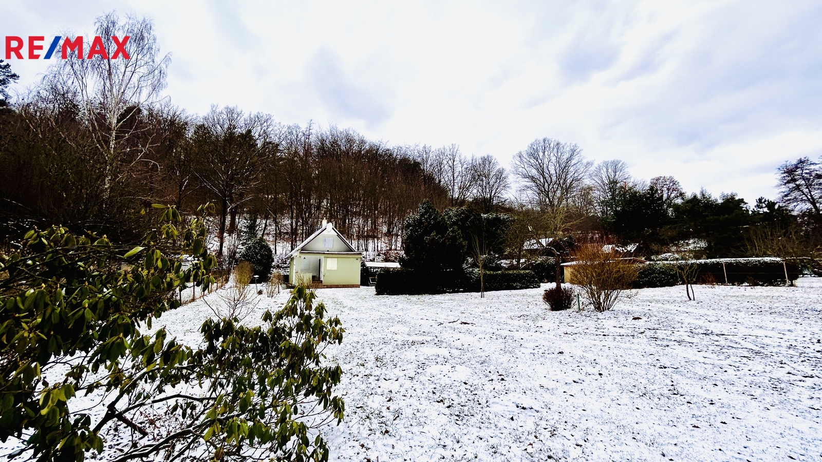 Pohled na chatu a zahradu od vjezdové brány