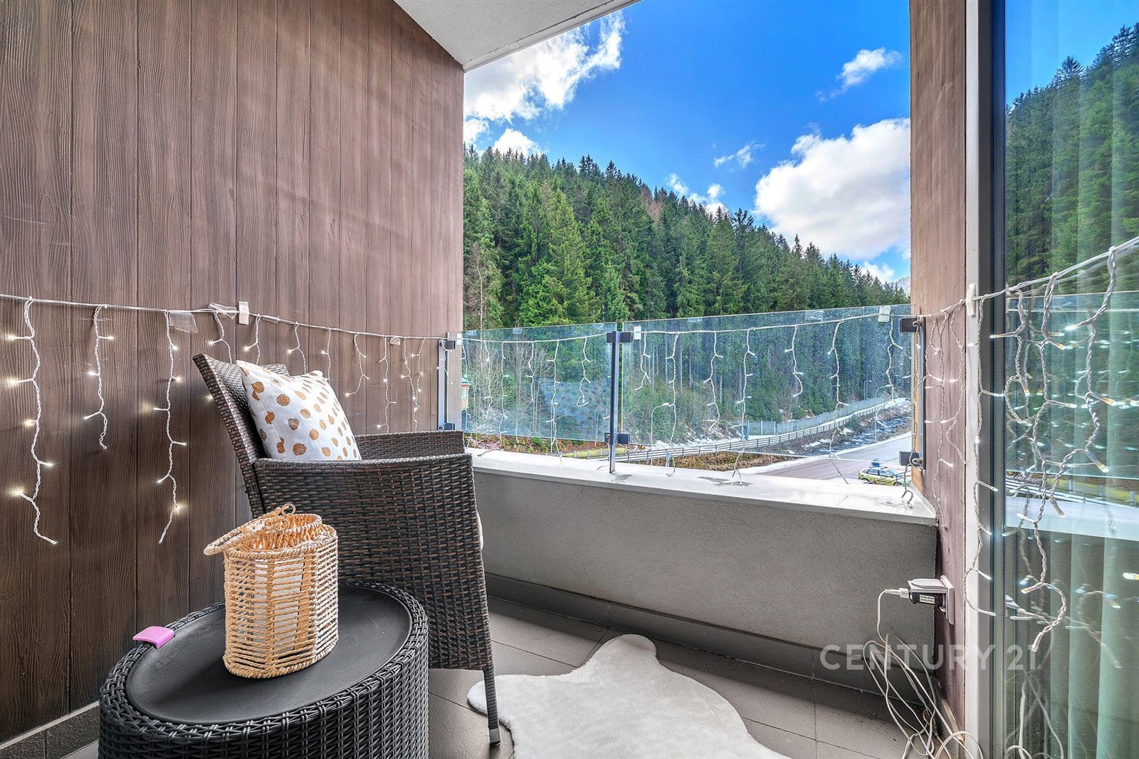 Balkón s moderní dlažbou a proskleným zábradlím na