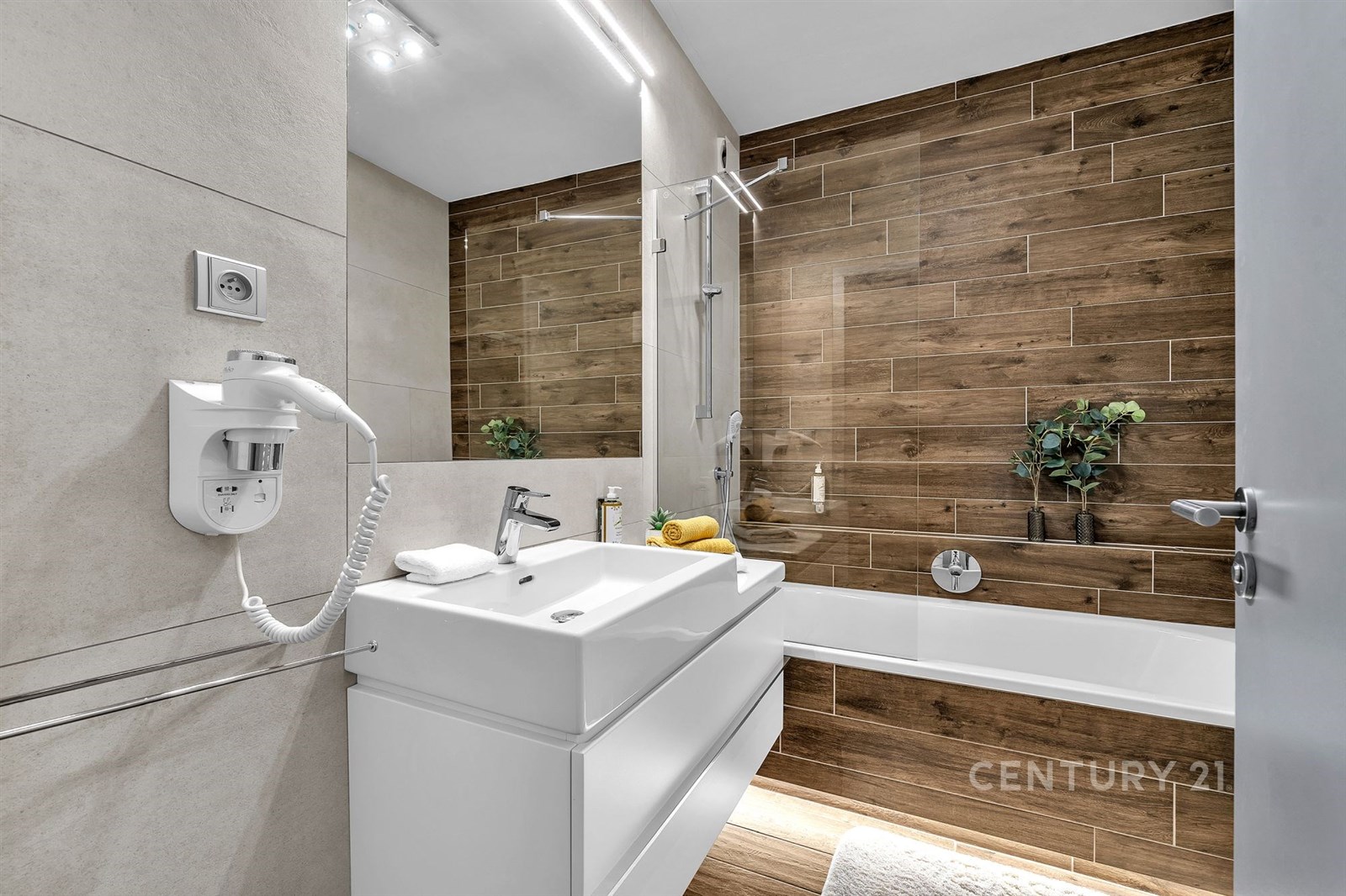 Moderní koupelna s keramickými obklady, vanou a zr