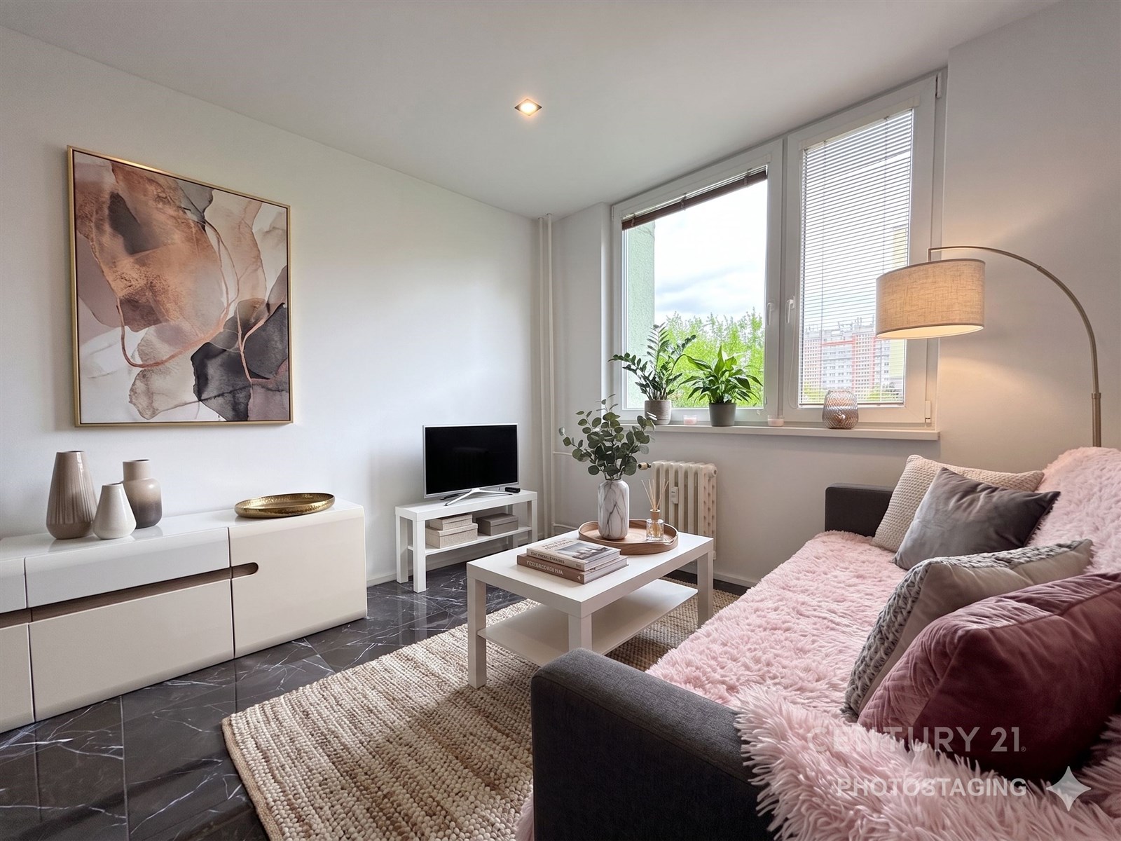 Světlý obývací pokoj s moderní dlažbou, velkými okny a elegantním nábytkem.