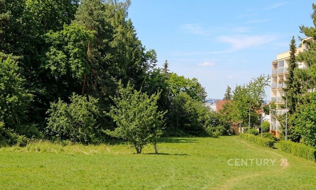 Travnatý pozemek obklopený stromy, vedle bytového domu. Klidná lokalita s možností výstavby, přírodní prostředí, dobrá občanská vybavenost.