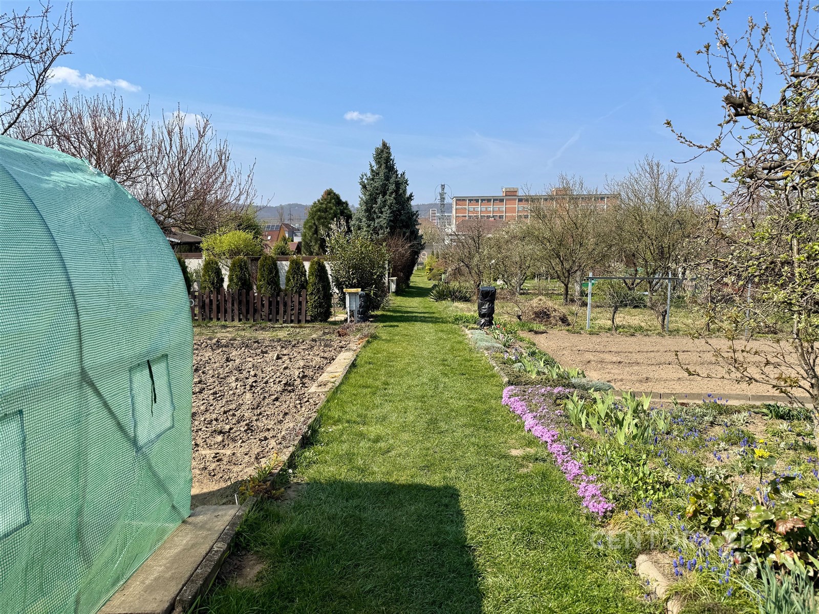 Zahrada s trávníkem a záhony, vybavená skleníkem a