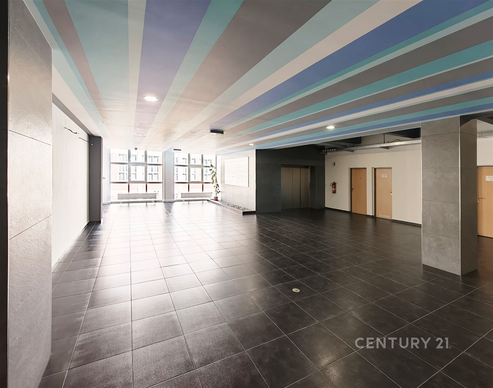 Moderní vstupní hala s dlažbou, světlý prostor s velkými okny a moderním designem stropu, vhodná pro komerční využití.